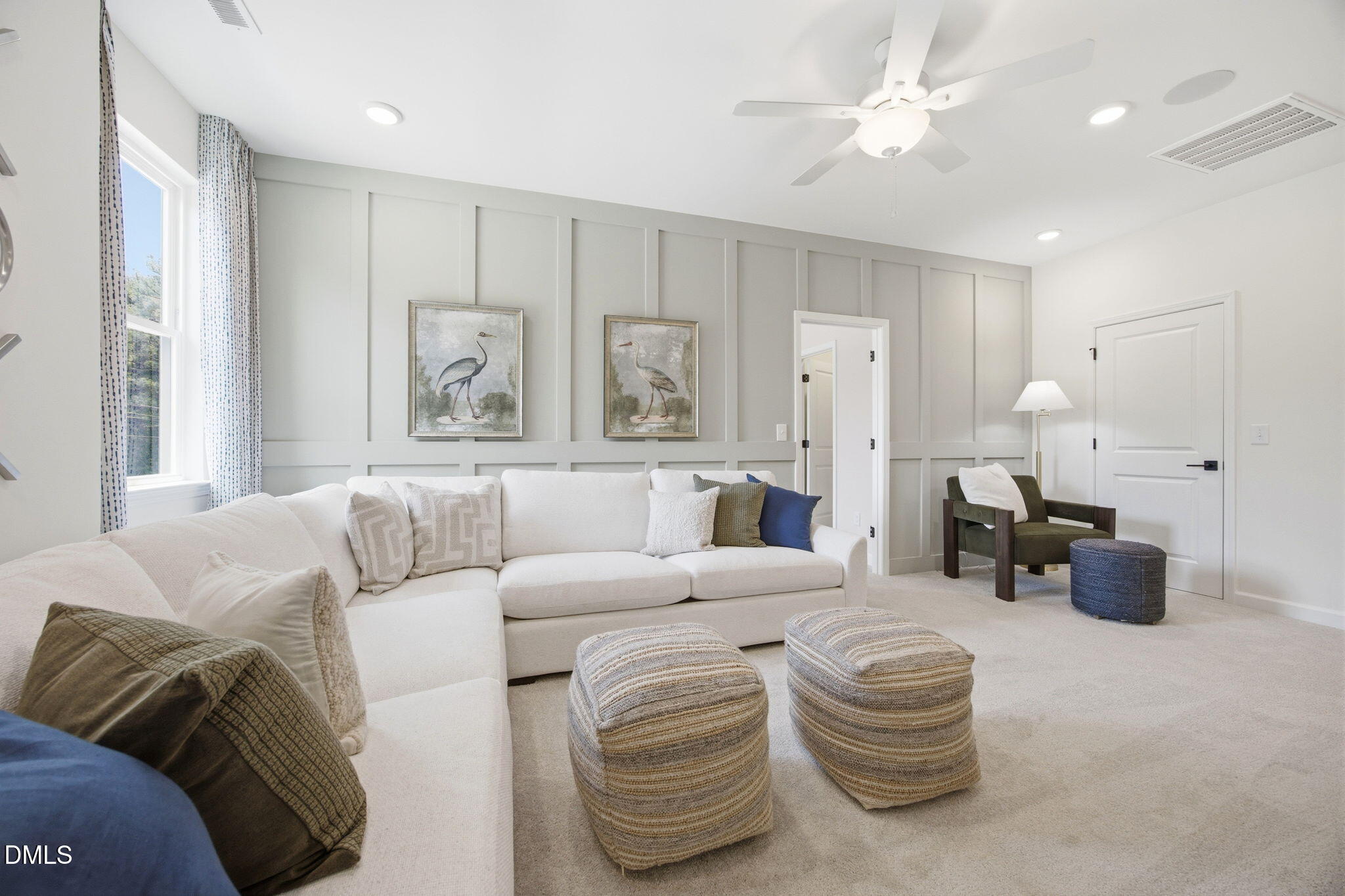Cozy loft area with white sectional sofa and board-and-batten wall in The Ashport M floor plan at Wendell Ridge, NC.