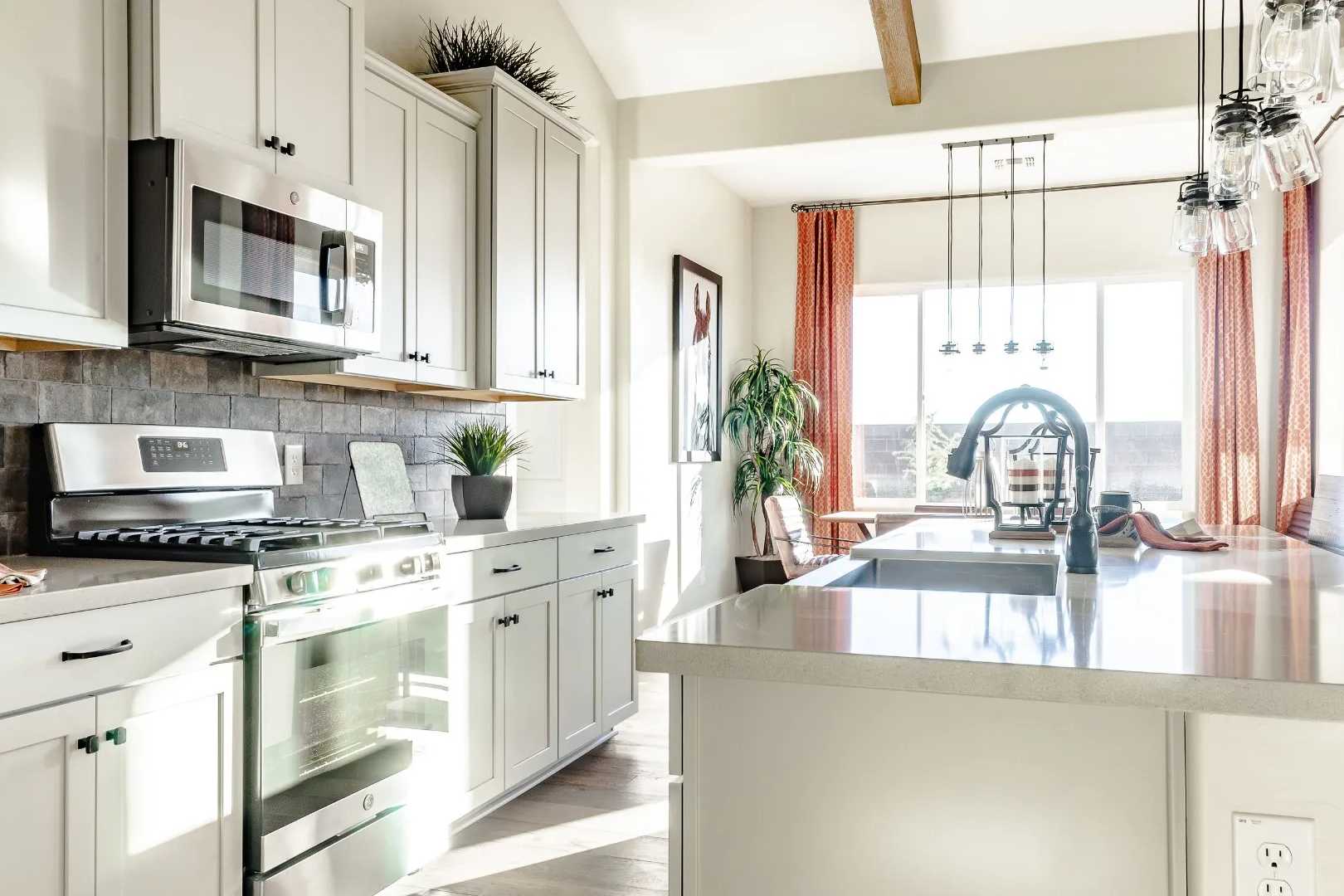 Spacious open-concept kitchen in Westwood Prescott AZ with white cabinets, stainless appliances, subway tile backsplash, and island