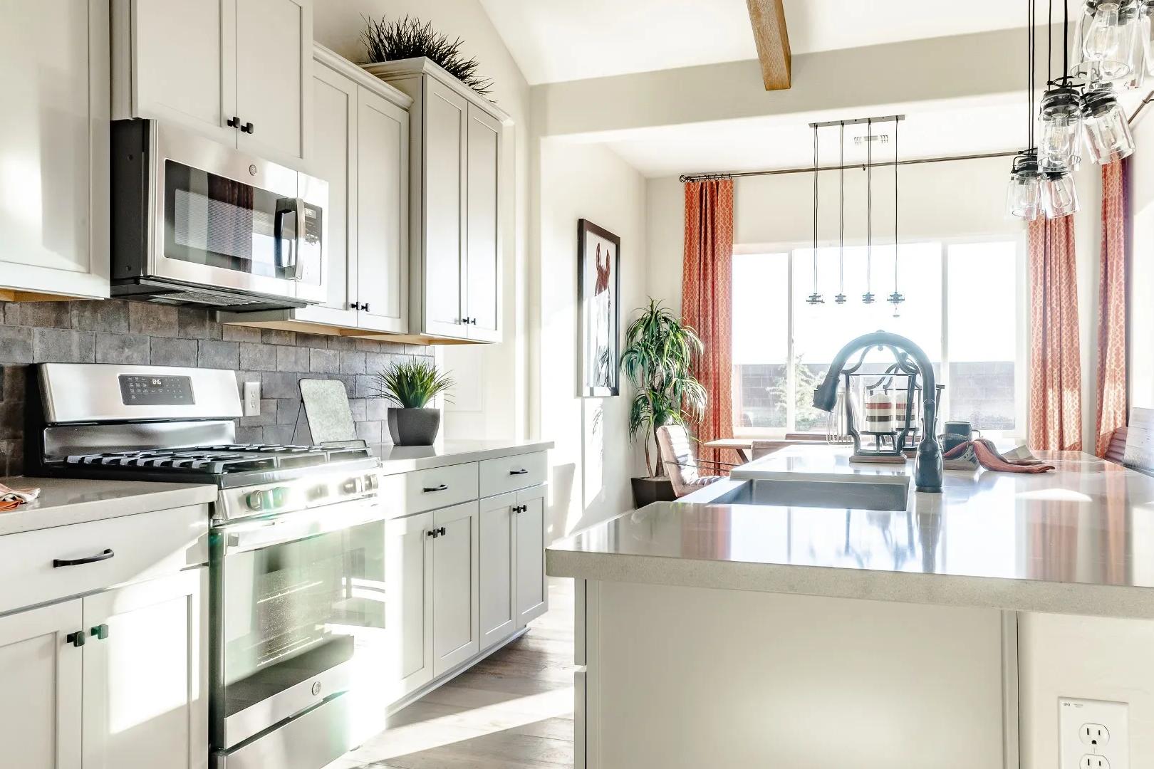 Spacious open-concept kitchen in Westwood Prescott AZ with white cabinets, stainless appliances, subway tile backsplash, and island