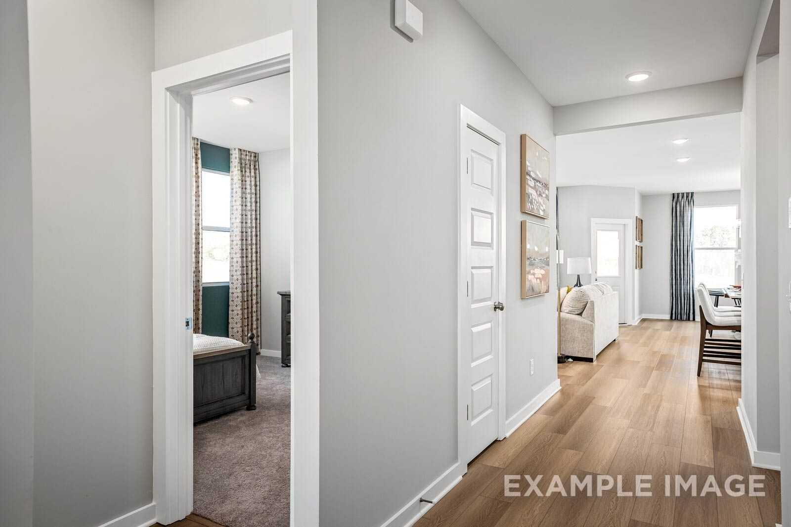 Bright hallway opening to bedroom with teal curtains and adjacent living-dining area in Davidson Homes Franklin C, Calista Farms, White House, TN