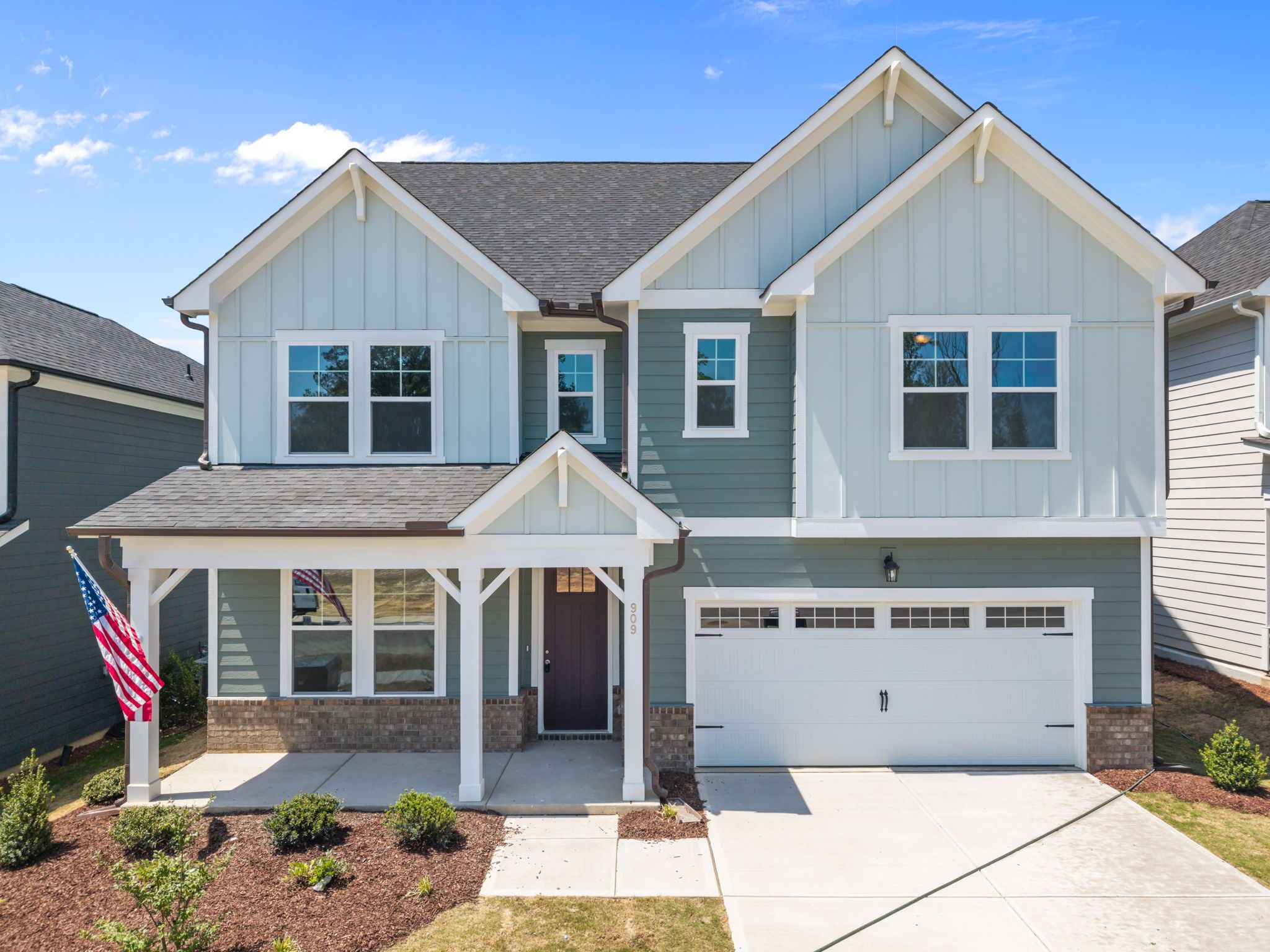 Spacious white kitchen with quartz island, bar stools, stainless appliances at Wendell Ridge, Wendell NC by Davidson Homes