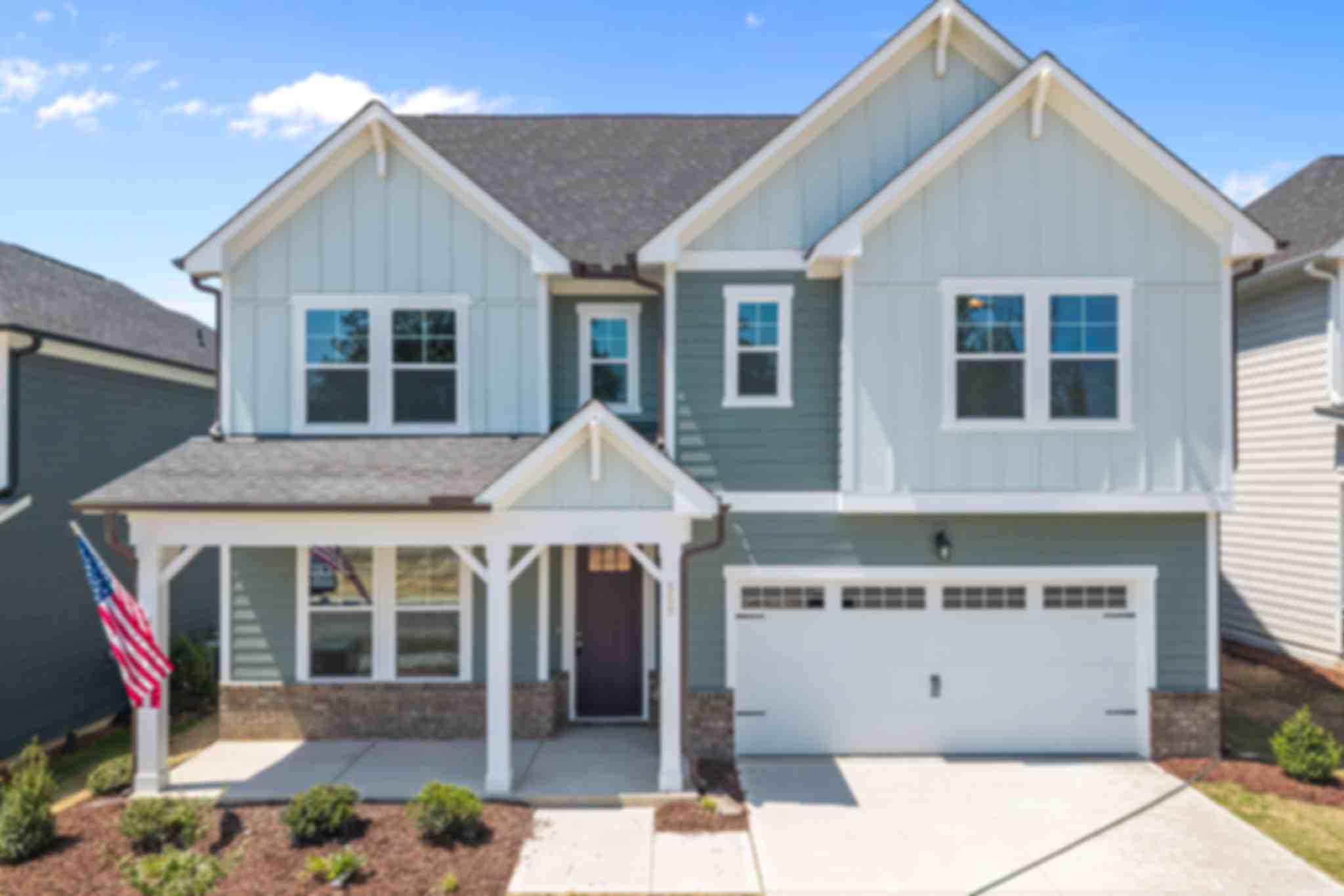 Spacious white kitchen with quartz island, bar stools, stainless appliances at Wendell Ridge, Wendell NC by Davidson Homes