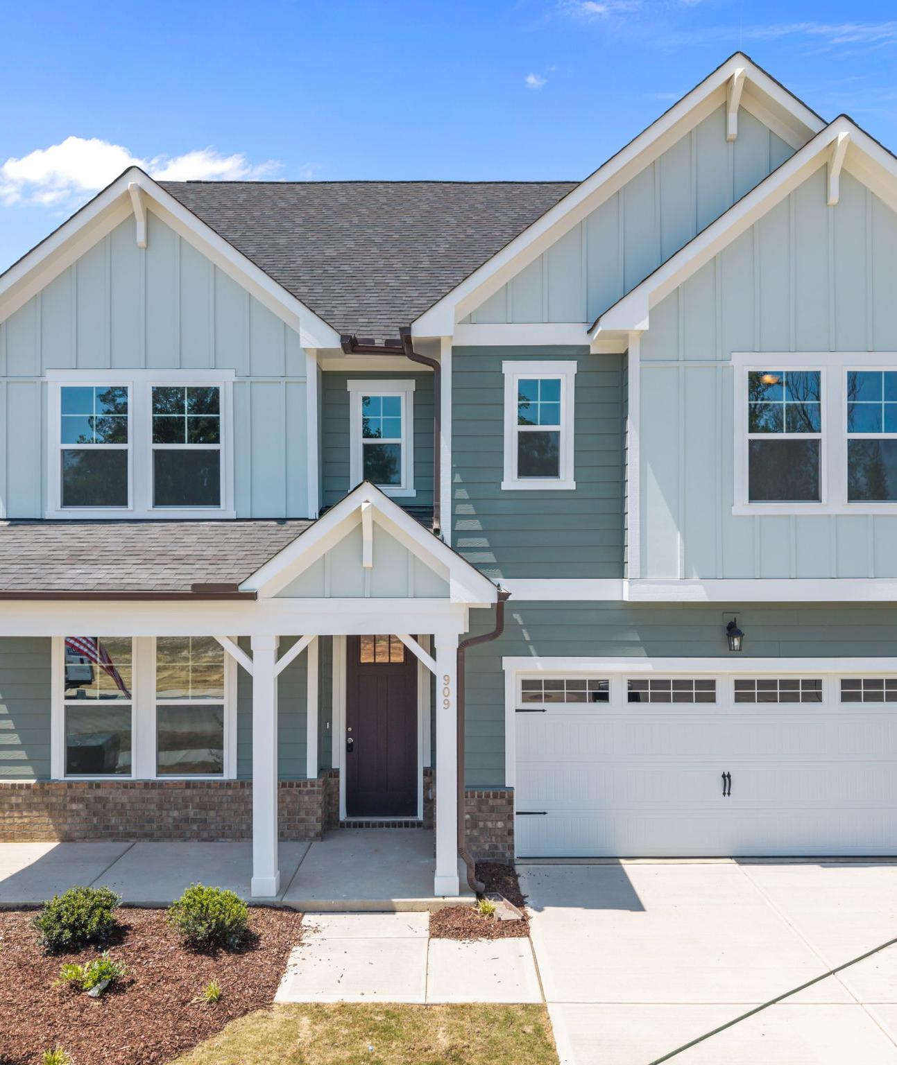 Spacious white kitchen with quartz island, bar stools, stainless appliances at Wendell Ridge, Wendell NC by Davidson Homes