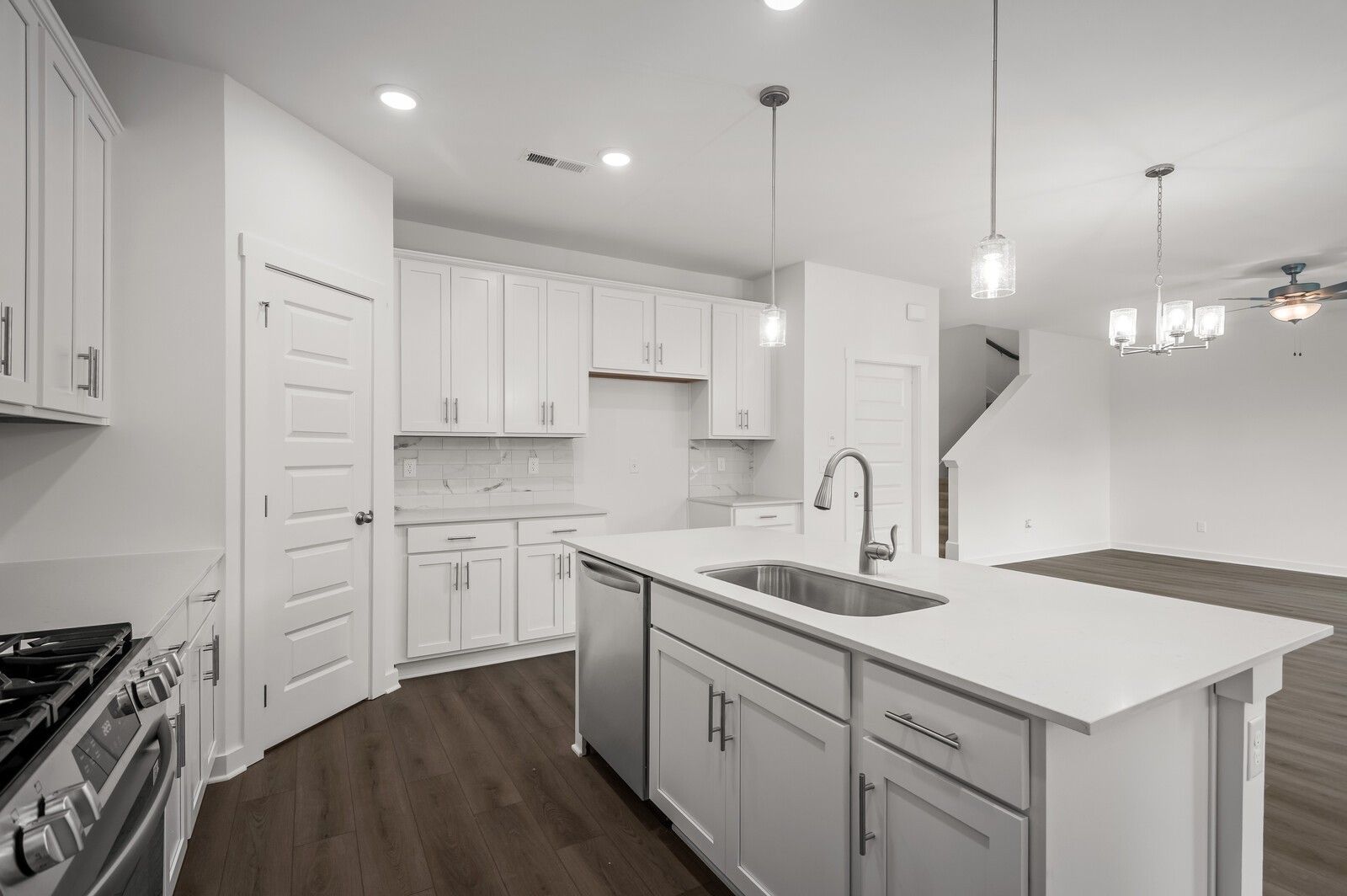 Modern kitchen with white cabinets, island, and stainless appliances in The Logan C floor plan, Calista Farms, Tennessee.