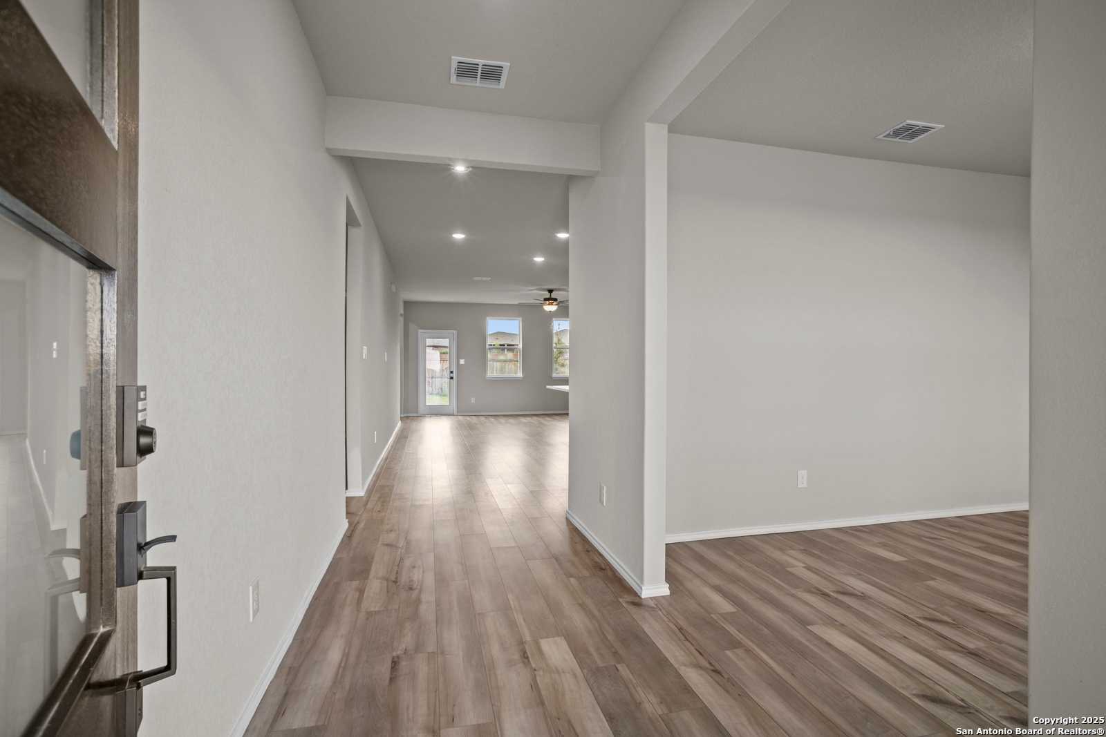 Spacious entry hallway with hardwood floors, neutral walls, and ceiling fan in Davidson Homes The Douglas F, San Antonio