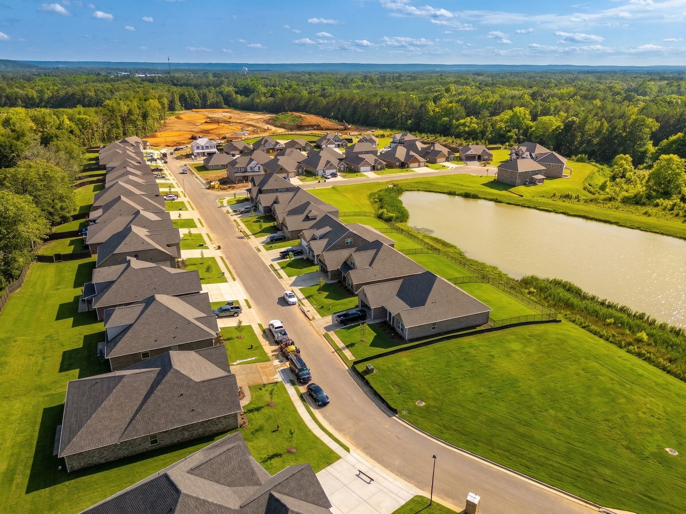 Aerial view of Cain Park neighborhood in Hartselle Alabama with new homes, scenic pond, streets and wooded surroundings