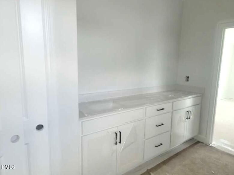Modern bathroom vanity with double sinks and white cabinetry in The Crawford D floor plan by Davidson Homes in Angier, NC.