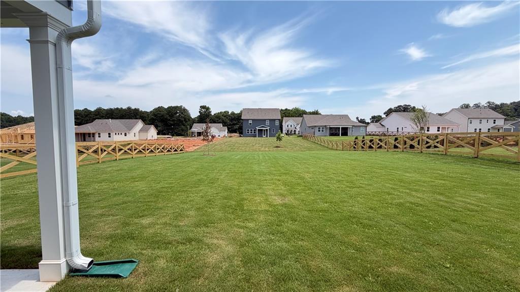 Large grassy backyard with wooden fencing at The Ash C floor plan in Wehunt Meadows, Hoschton, Georgia.