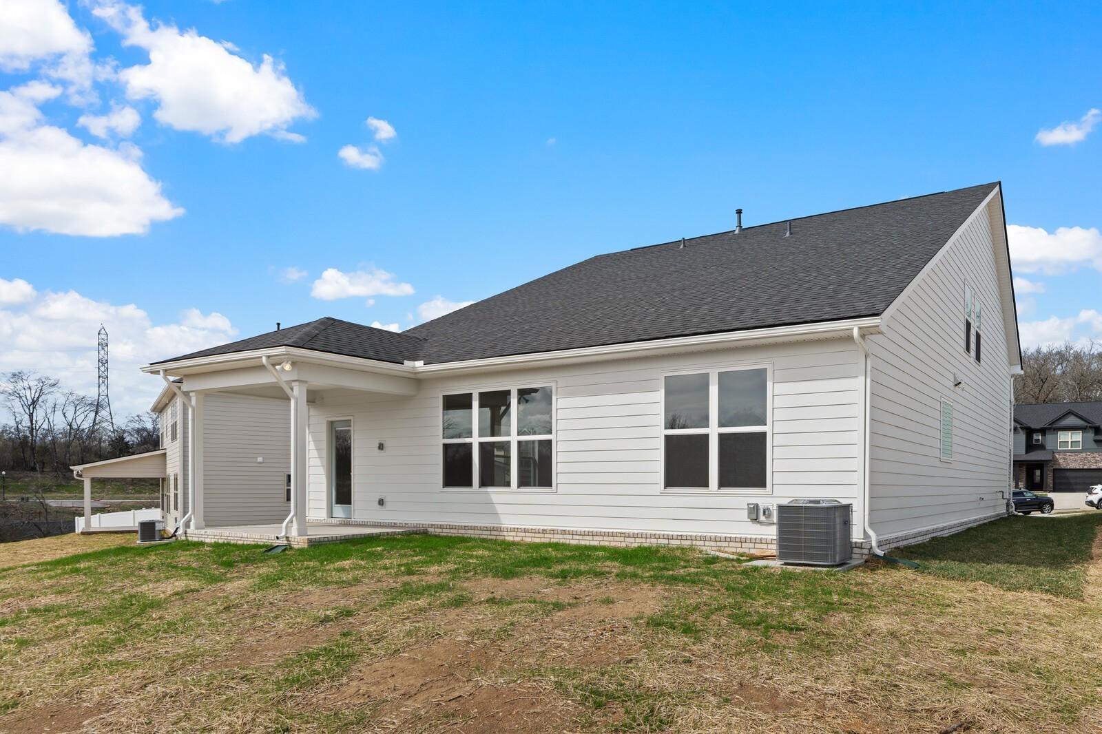 Modern two-story white home with two-car garage, covered porch, and lush yard in Woods Crossing, Gallatin, Tennessee - Davidson Homes Ridgeport