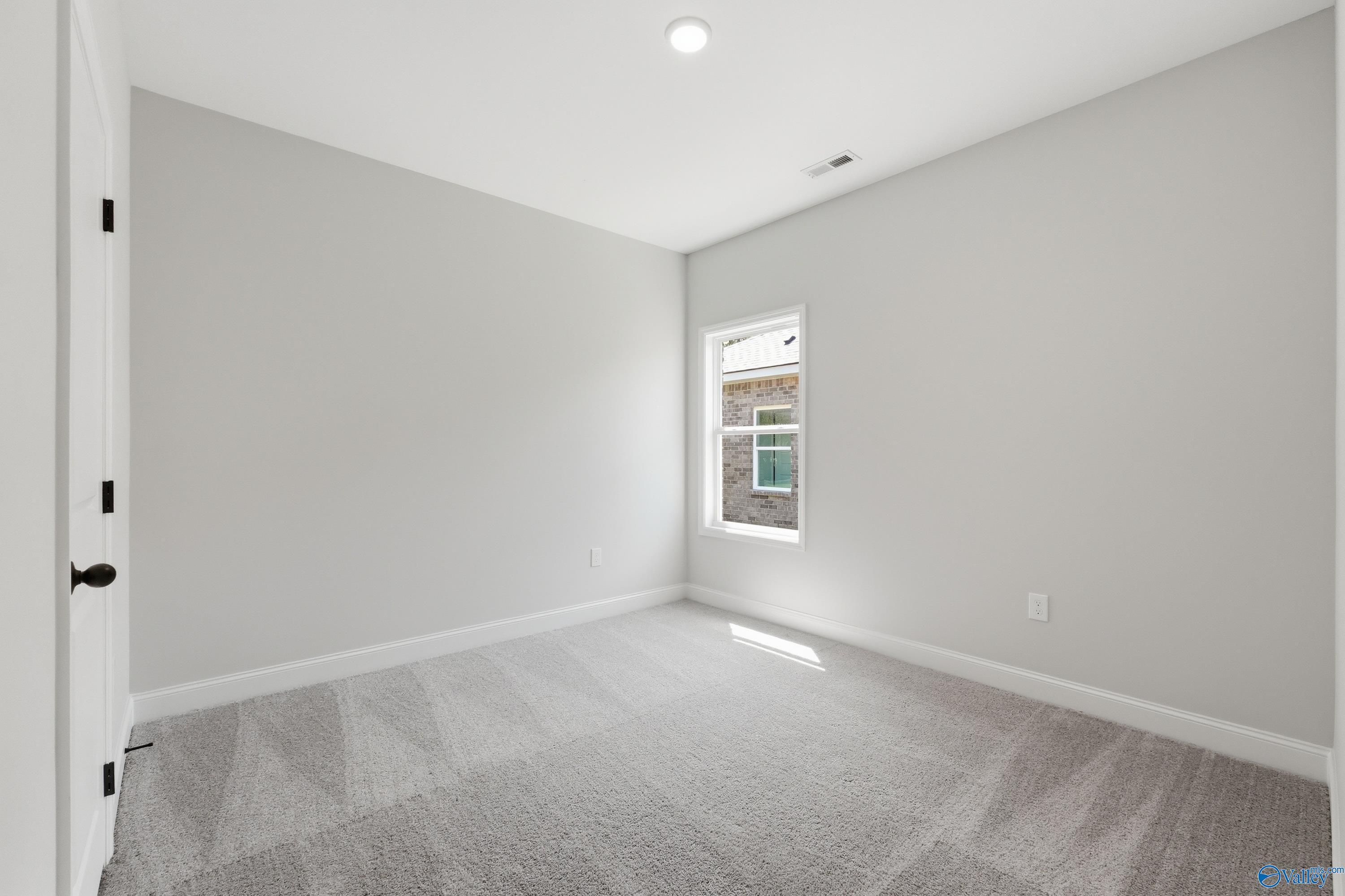 Bright secondary bedroom with gray walls, plush carpet, and window view in Davidson Homes The Franklin, Jaguar Hills, Huntsville