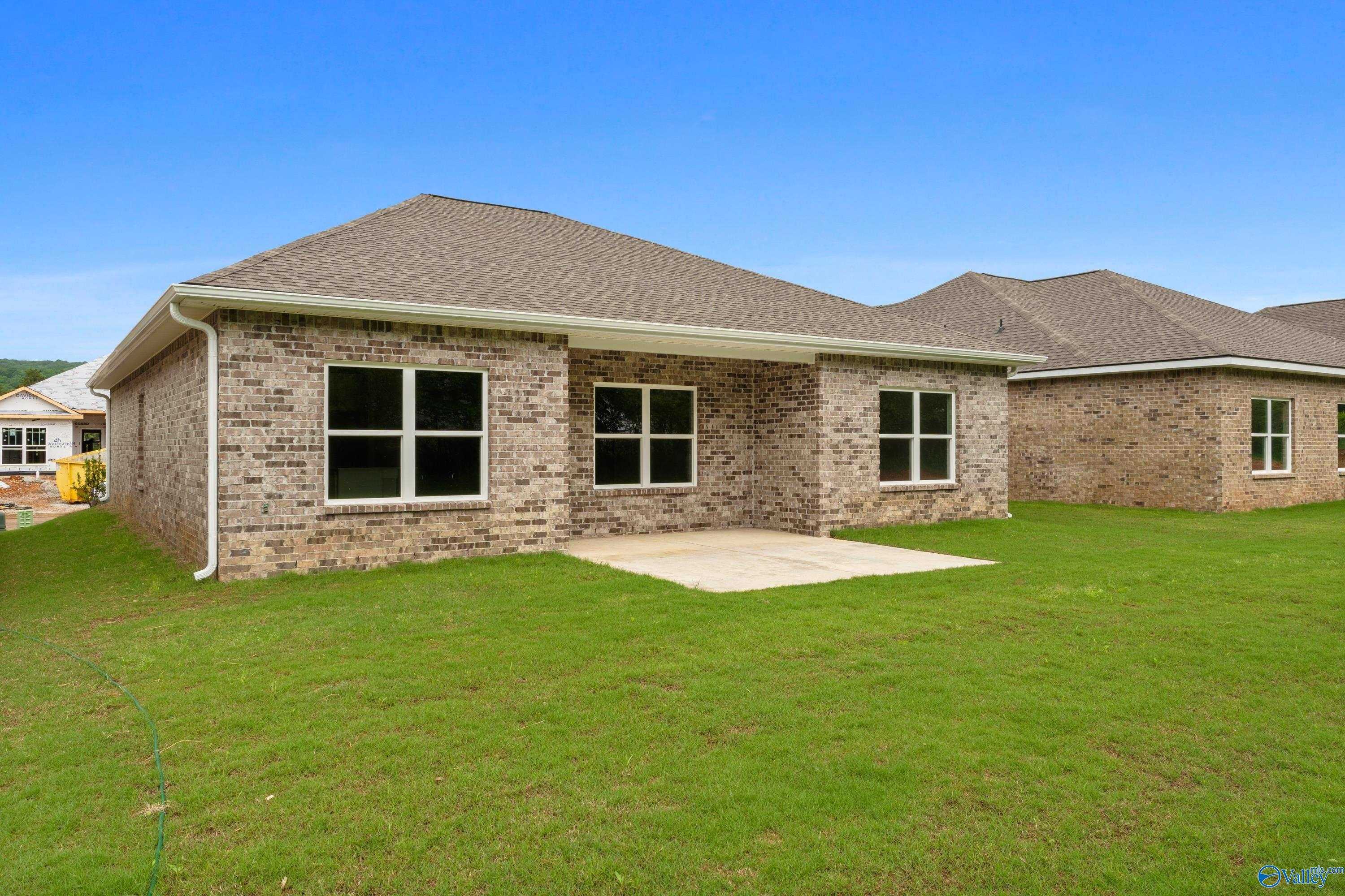 Brick ranch-style home exterior with garage, large windows, and green lawn in Jaguar Hills, Huntsville, Alabama