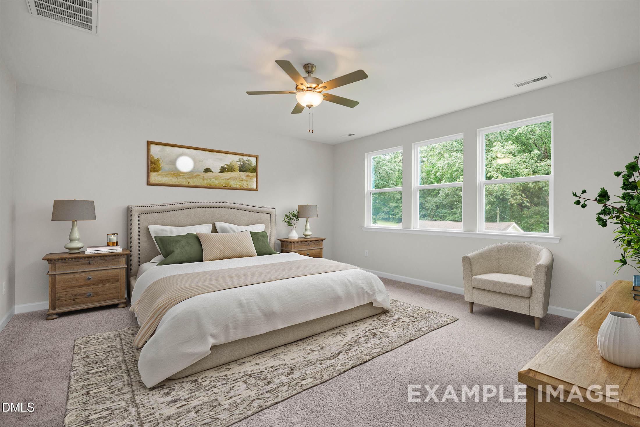 Cozy bedroom with king bed, beige linens, ceiling fan, large windows overlooking trees in The Aspen C by Davidson Homes, Apex, NC