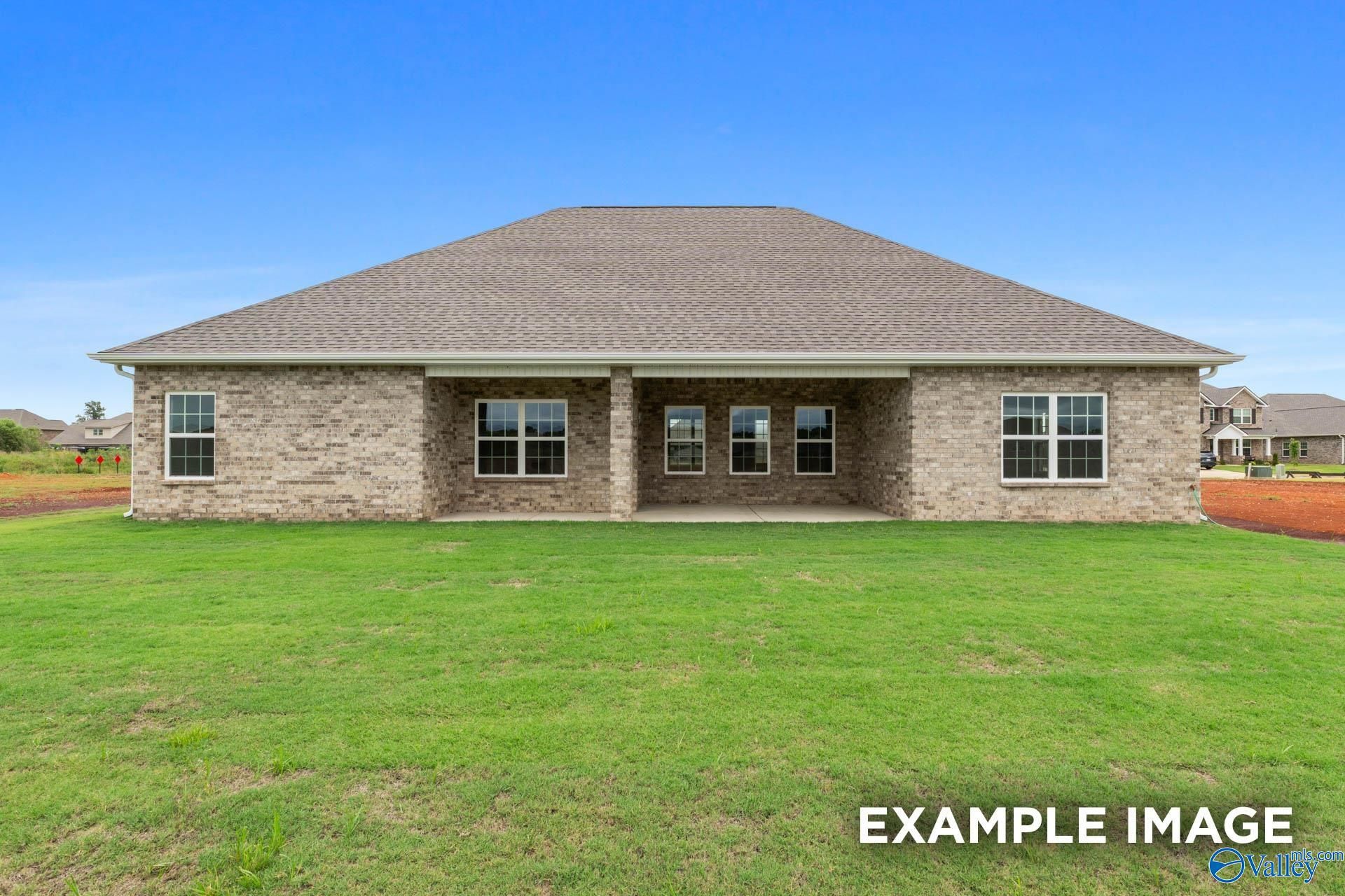 Two-story brick Emory home with covered back patio, large windows, and lush green yard in Kendall Farms, Toney, Alabama