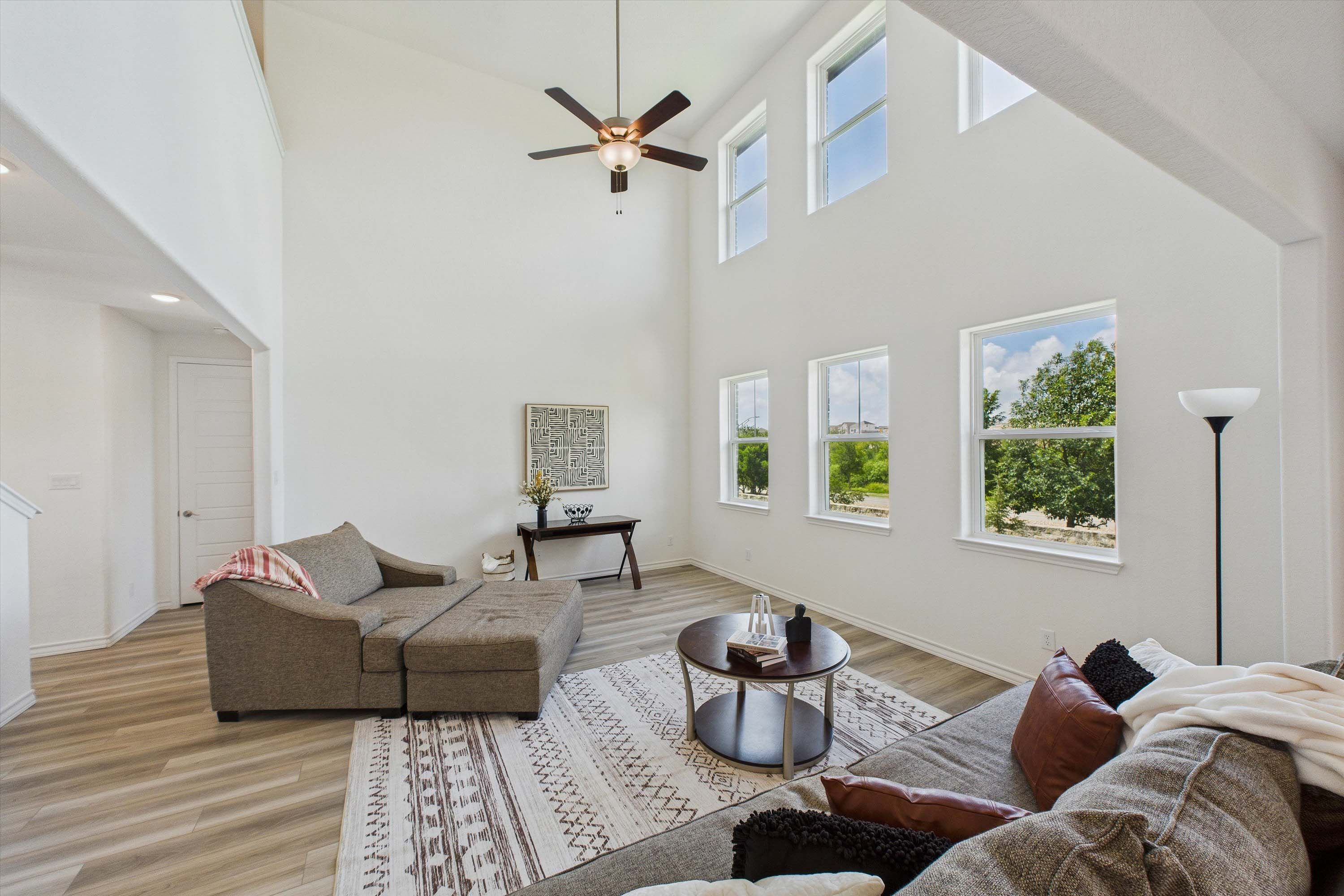 Spacious two-story living room in The Danbury by Davidson Homes featuring soaring ceilings and natural light.
