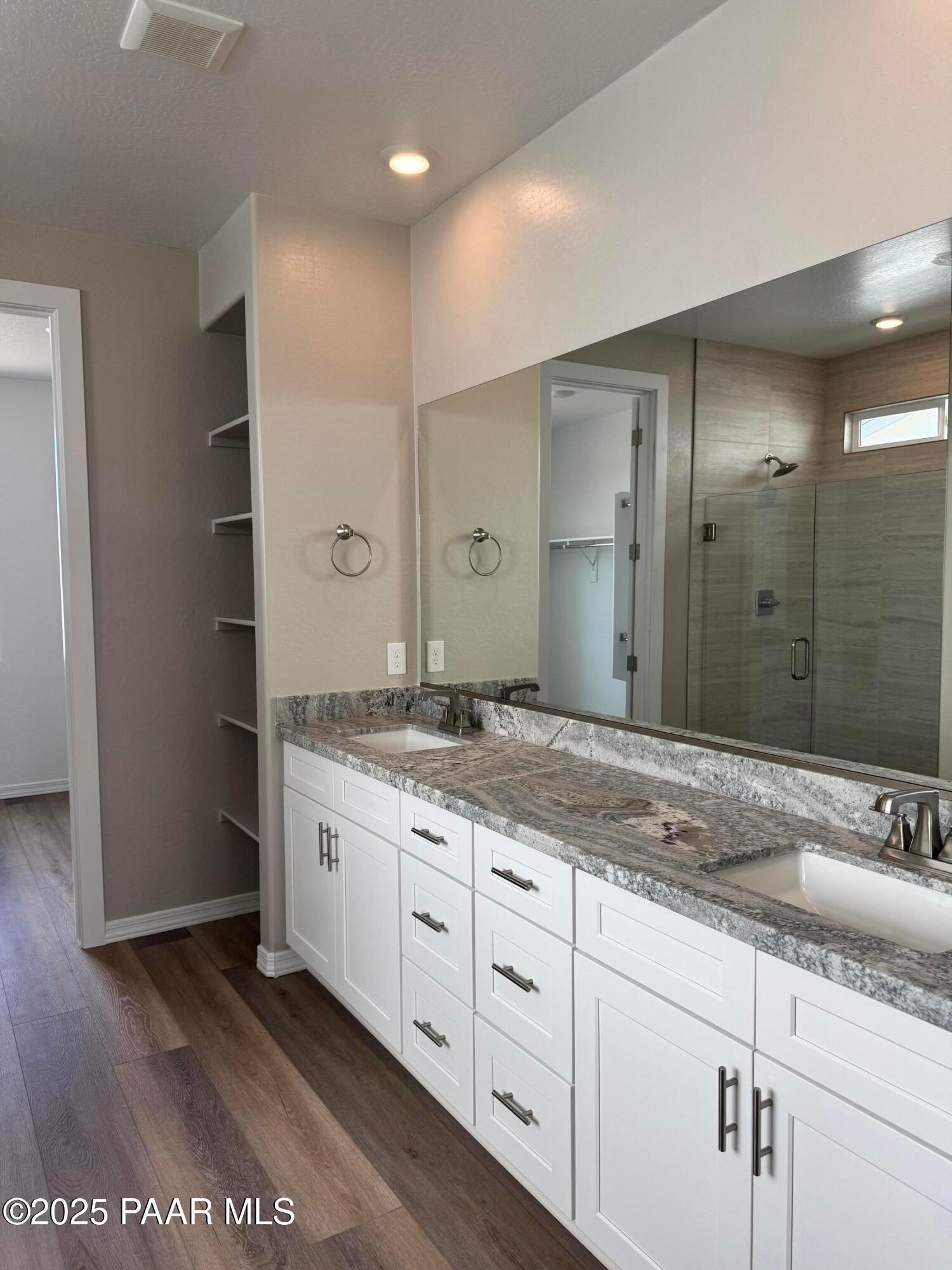 Modern master bathroom featuring double vanity with quartz counters, white cabinets, glass shower in Davidson Homes The Monarch A, Prescott AZ