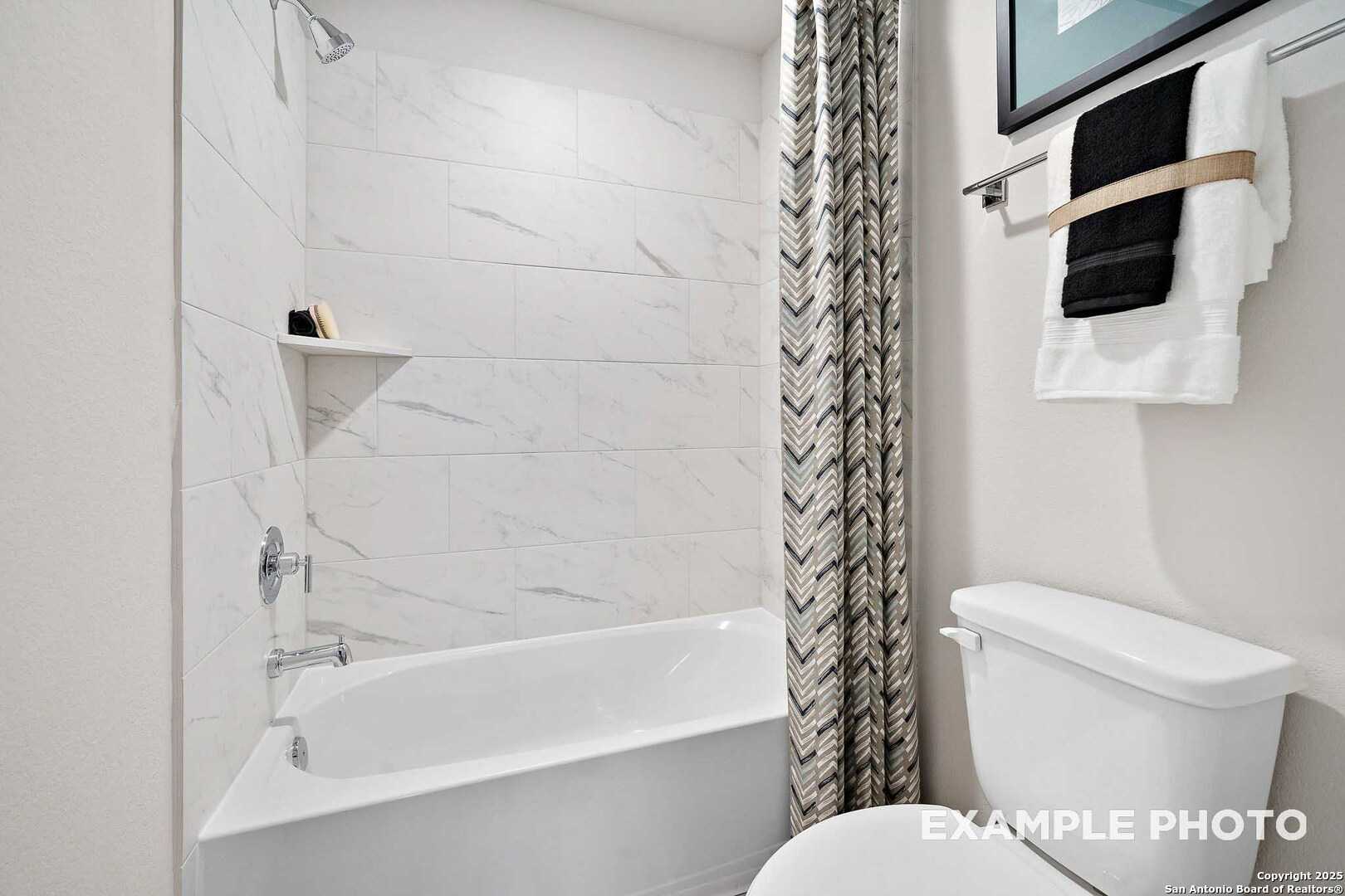 Modern bathroom featuring freestanding tub, glass shower, subway tile walls in Davidson Homes The San Marcos D, San Antonio, Texas