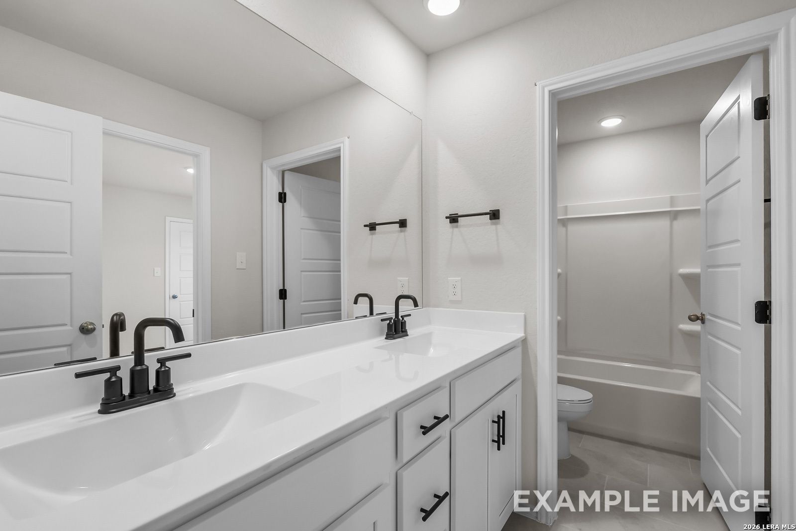 Modern bathroom with dual vanity, matte black fixtures, and tub-shower combo in Davidson Homes' Sequoia C, San Antonio.