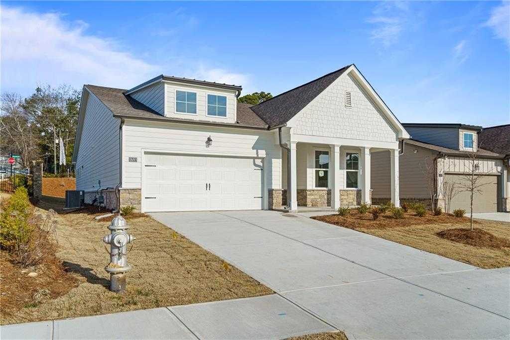 Modern white single-story home with 2-car garage, covered porch, and landscaping in Kelly Preserve, Loganville, Georgia by Davidson Homes The Edison A