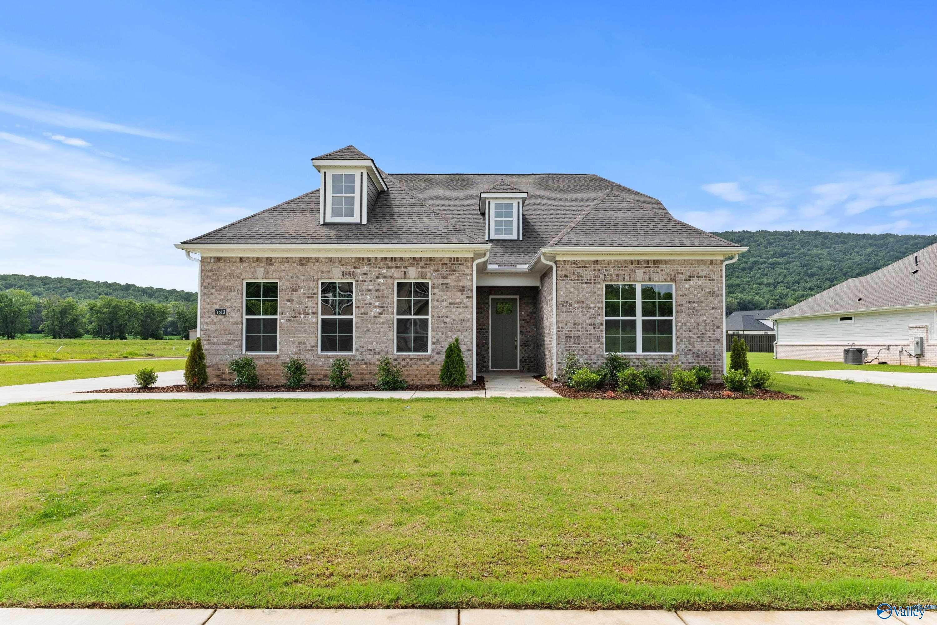 Brick 1.5-story Oxford B home with gabled roof, dormers, and landscaped front yard in The Meadows at Hampton Cove, Owens Cross Roads, Alabama