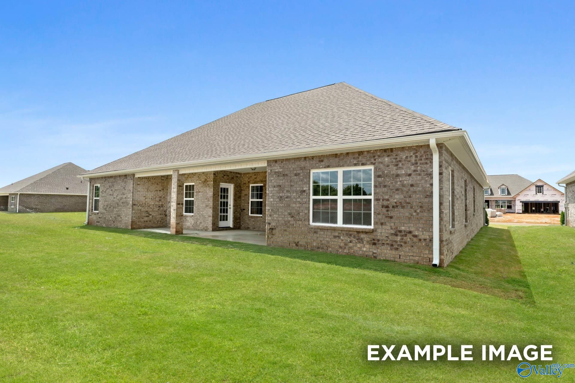 Single-story brick home with covered porch, double windows, and lush green lawn in Riverton Preserve, Huntsville, Alabama