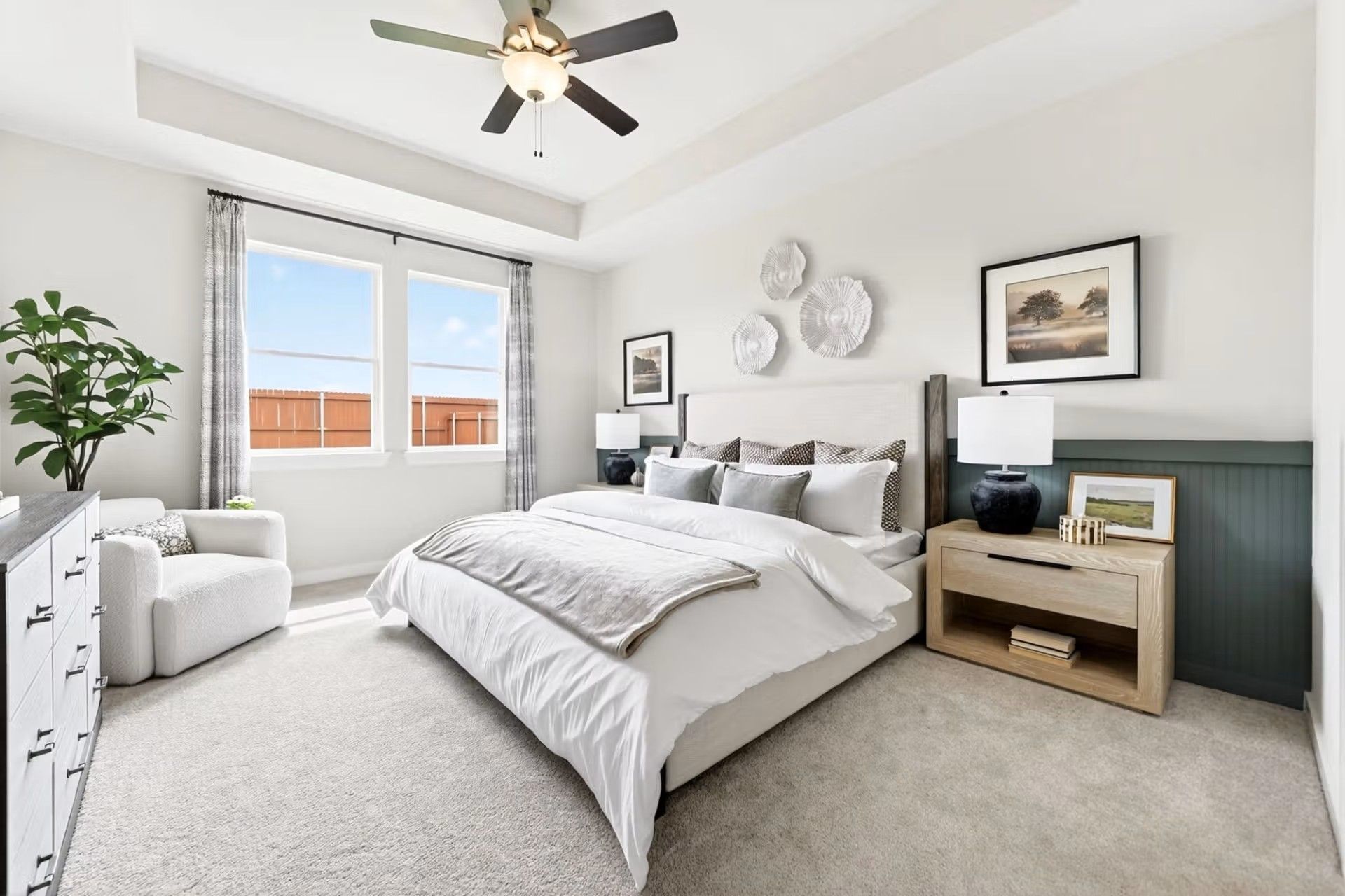 Bright primary bedroom with tray ceiling and modern decor in The Laurel I floor plan by Davidson Homes in Heartland, TX.