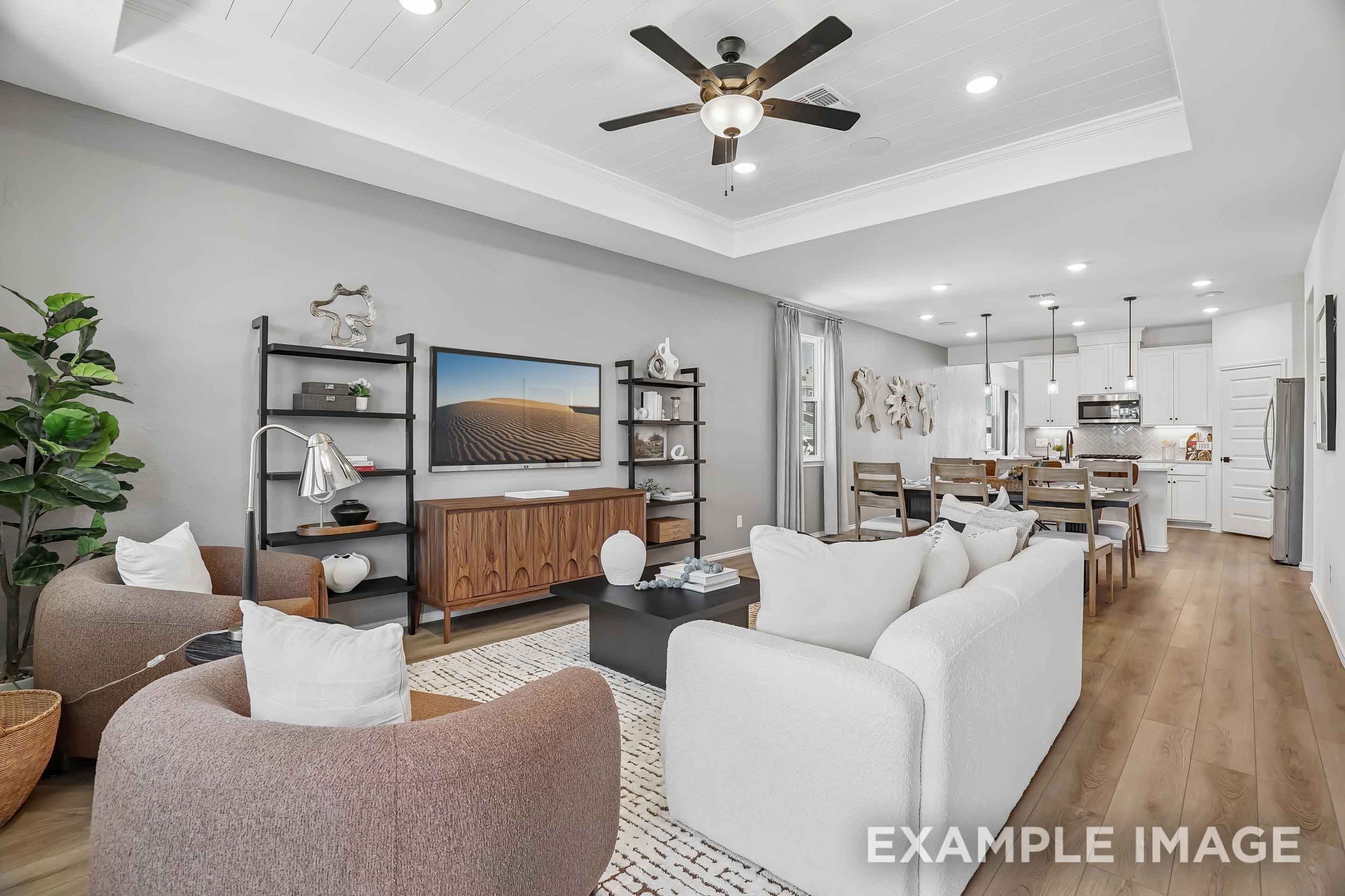 Open-concept living room and kitchen in The Pinecrest D design featuring a coffered ceiling and modern interior finishes.