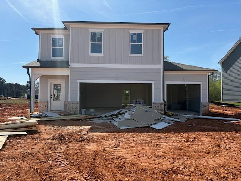 Modern two-story gray home with 3-car garage and front door in Cedar Farms construction site, Winder, Georgia