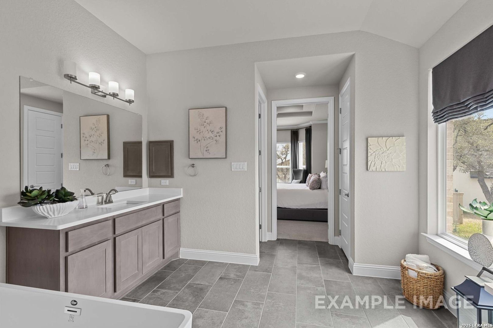 Modern master bathroom with dual vanity in The Garner C floor plan at The Reserve at Potranco Oaks, Castroville, Texas.