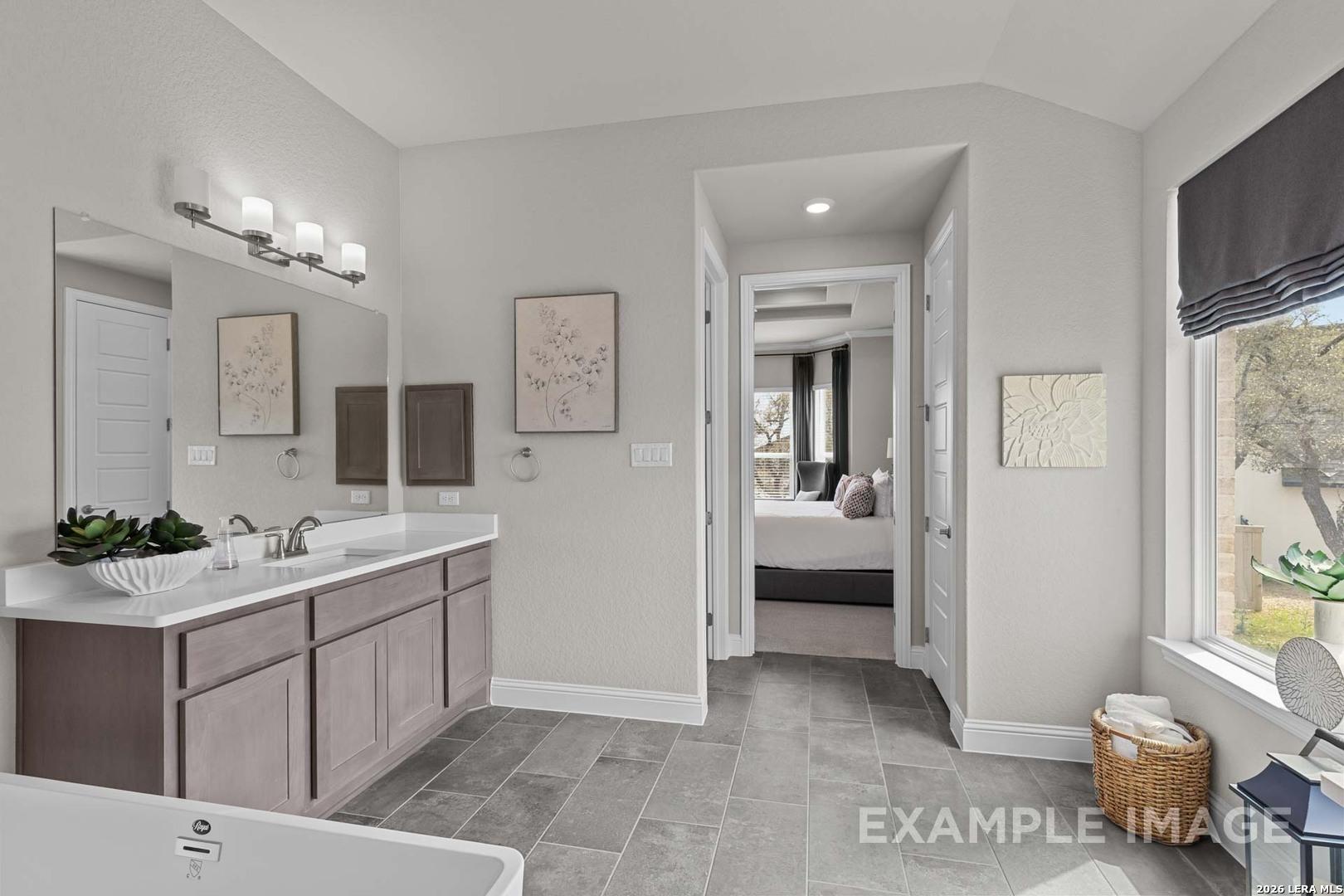 Modern master bathroom with dual vanity in The Garner C floor plan at The Reserve at Potranco Oaks, Castroville, Texas.