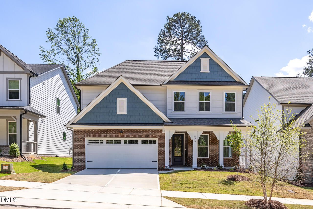 Two-story Ashport L floor plan by Davidson Homes in Sage on North Main, Wake Forest, NC with brick facade and 2-car garage.