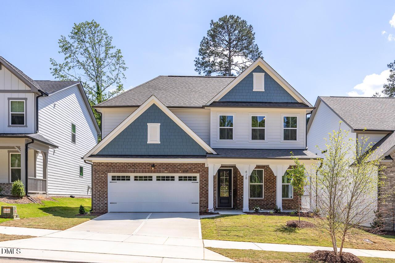Two-story Ashport L floor plan by Davidson Homes in Sage on North Main, Wake Forest, NC with brick facade and 2-car garage.