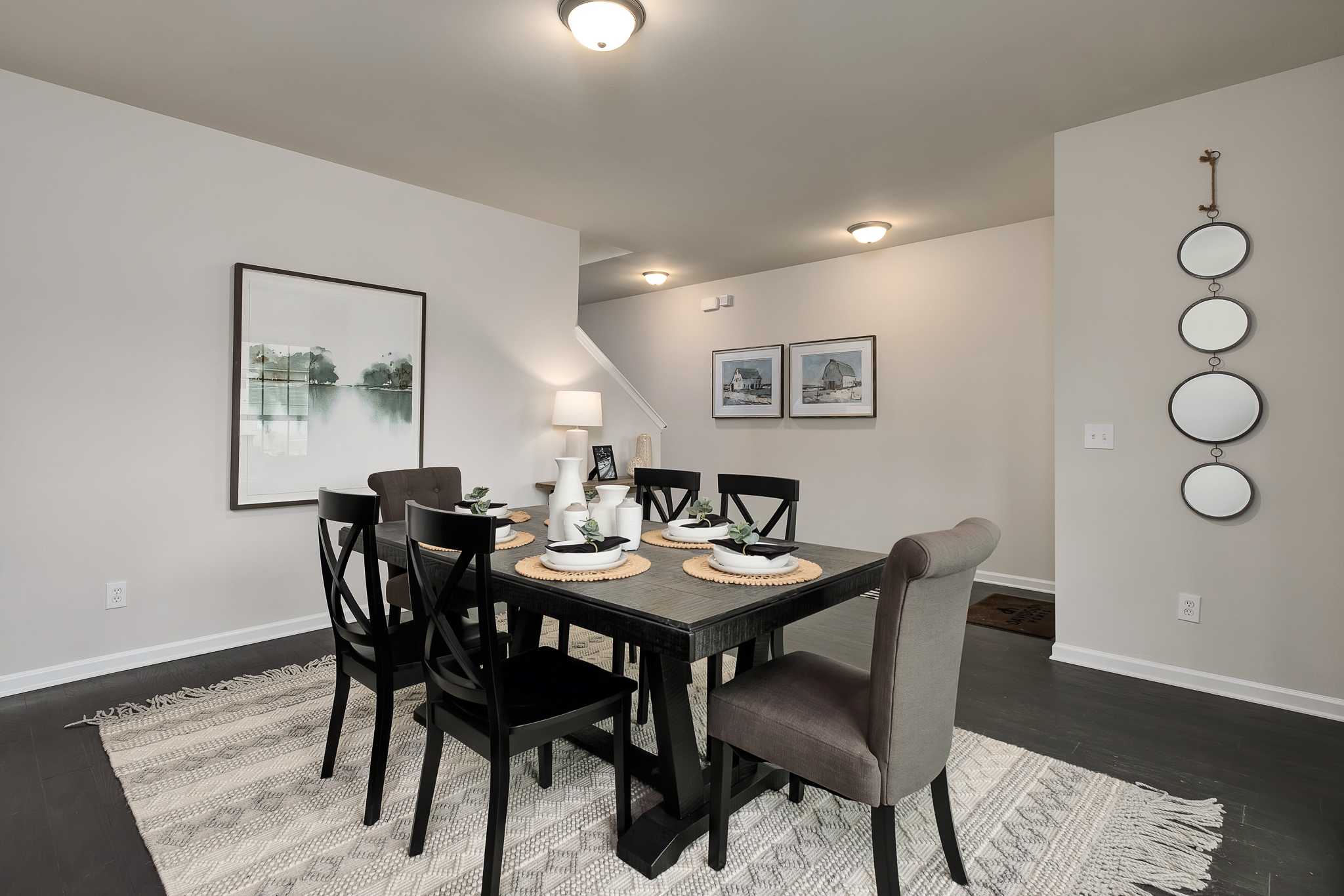 Elegant dining room at The Reserve at Overton in Hampton Cove, Alabama with wooden table, upholstered chairs, and wall mirrors