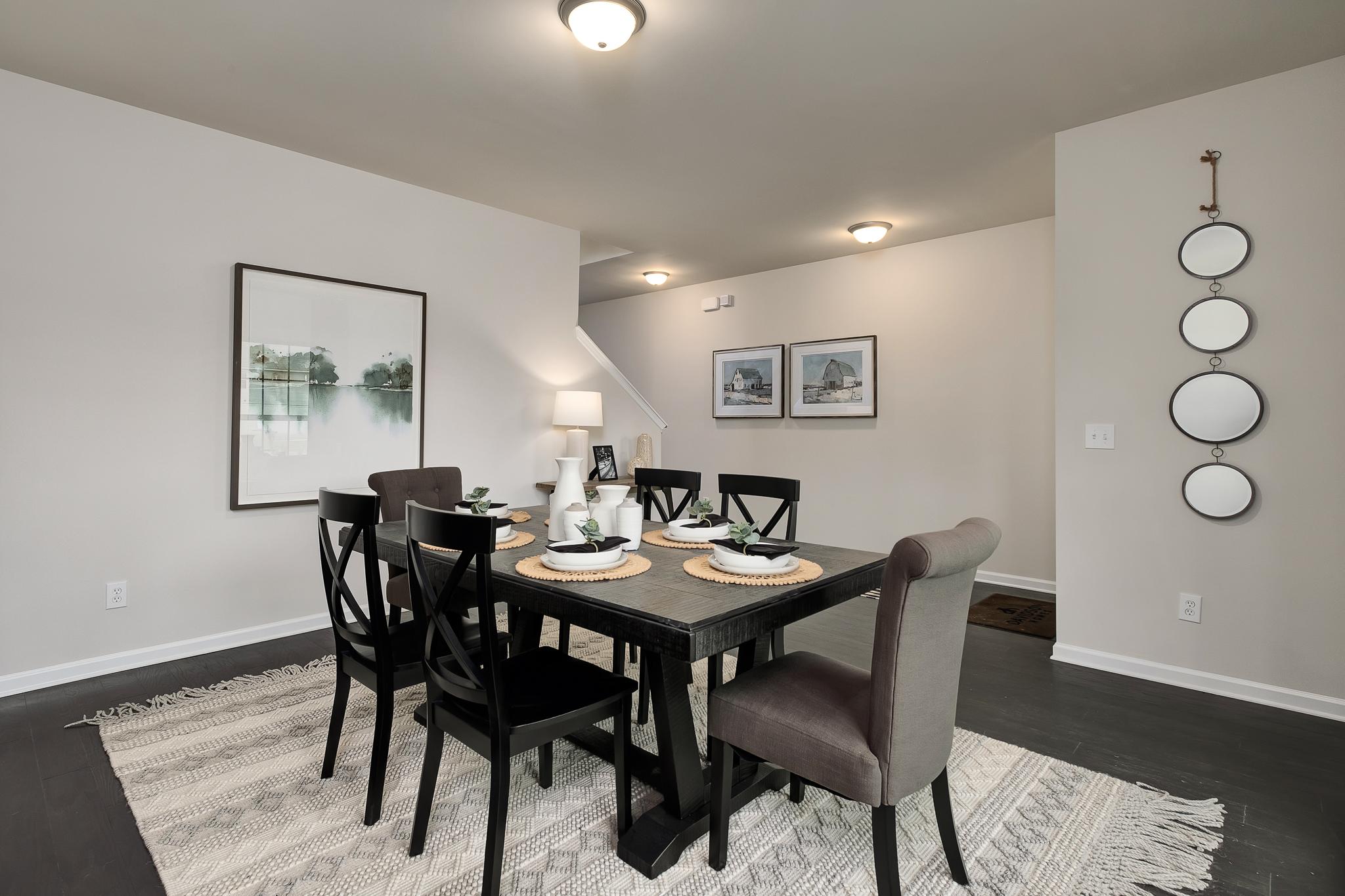 Elegant dining room at The Reserve at Overton in Hampton Cove, Alabama with wooden table, upholstered chairs, and wall mirrors