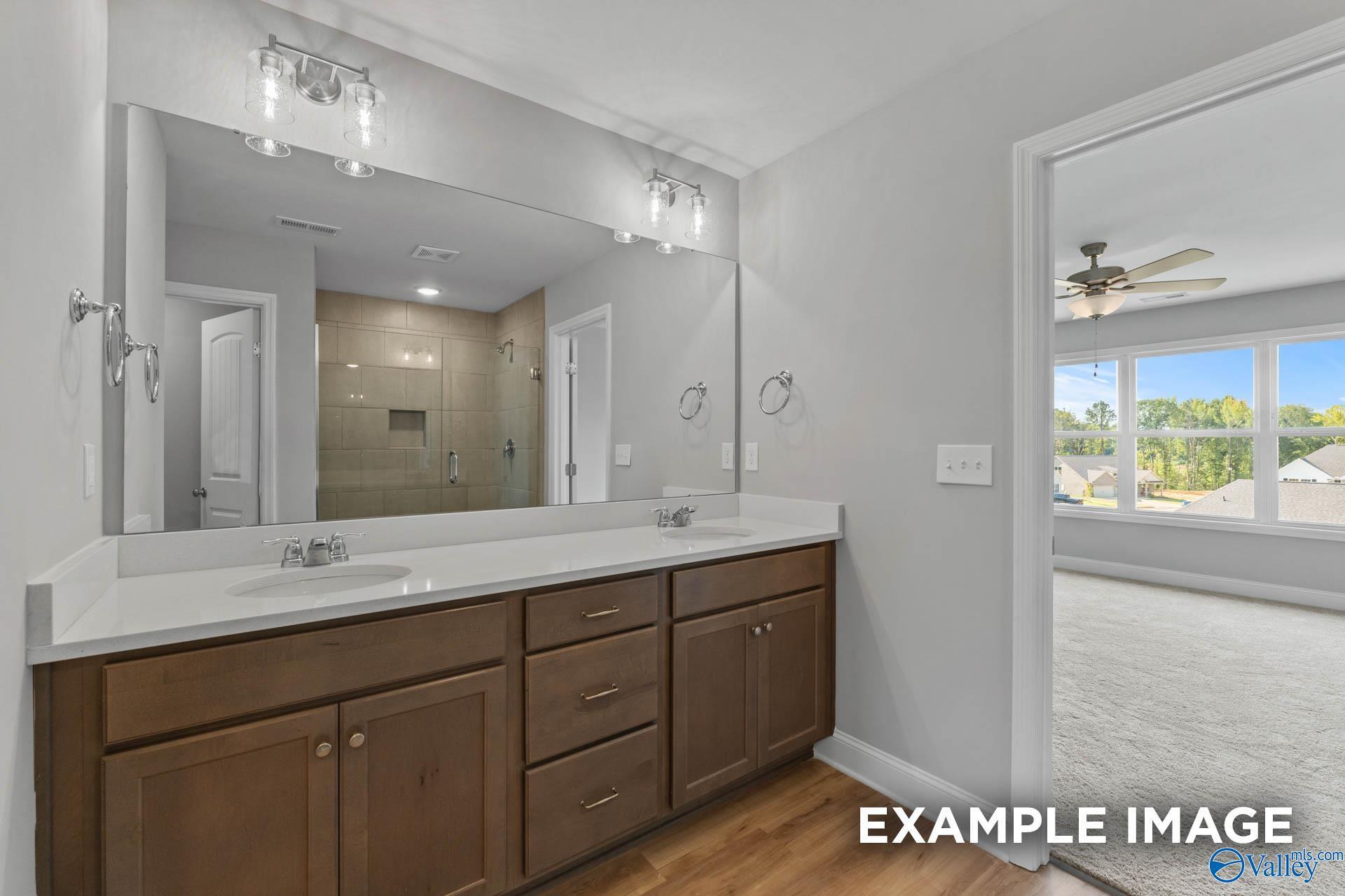 Double vanity bathroom with walk-in tiled shower in The Shelby B floor plan at Walker's Hill, Meridianville, Alabama.