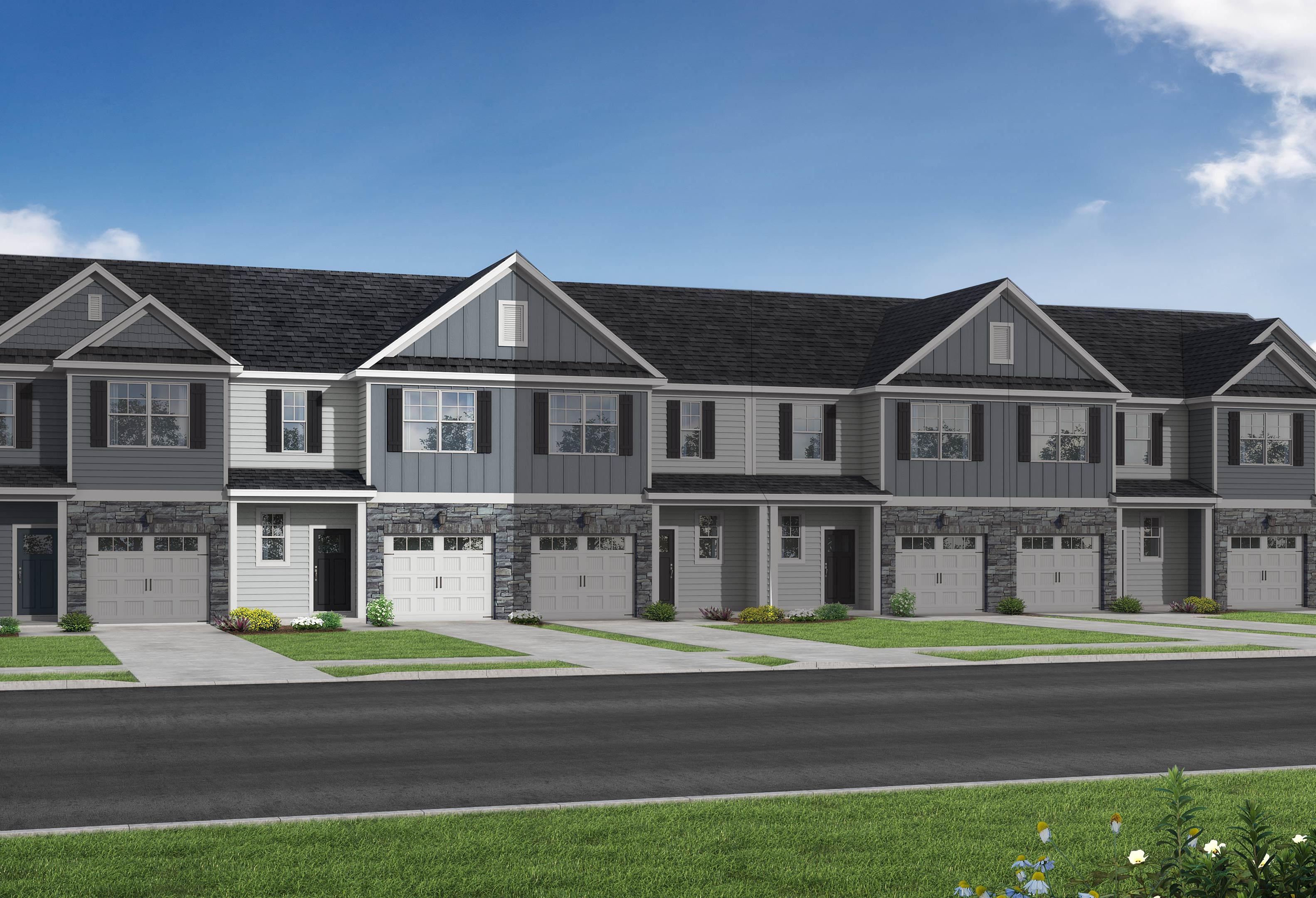 Modern row of The Warren two-story townhomes with gray siding, attached garages, and green lawns in Fuquay-Varina