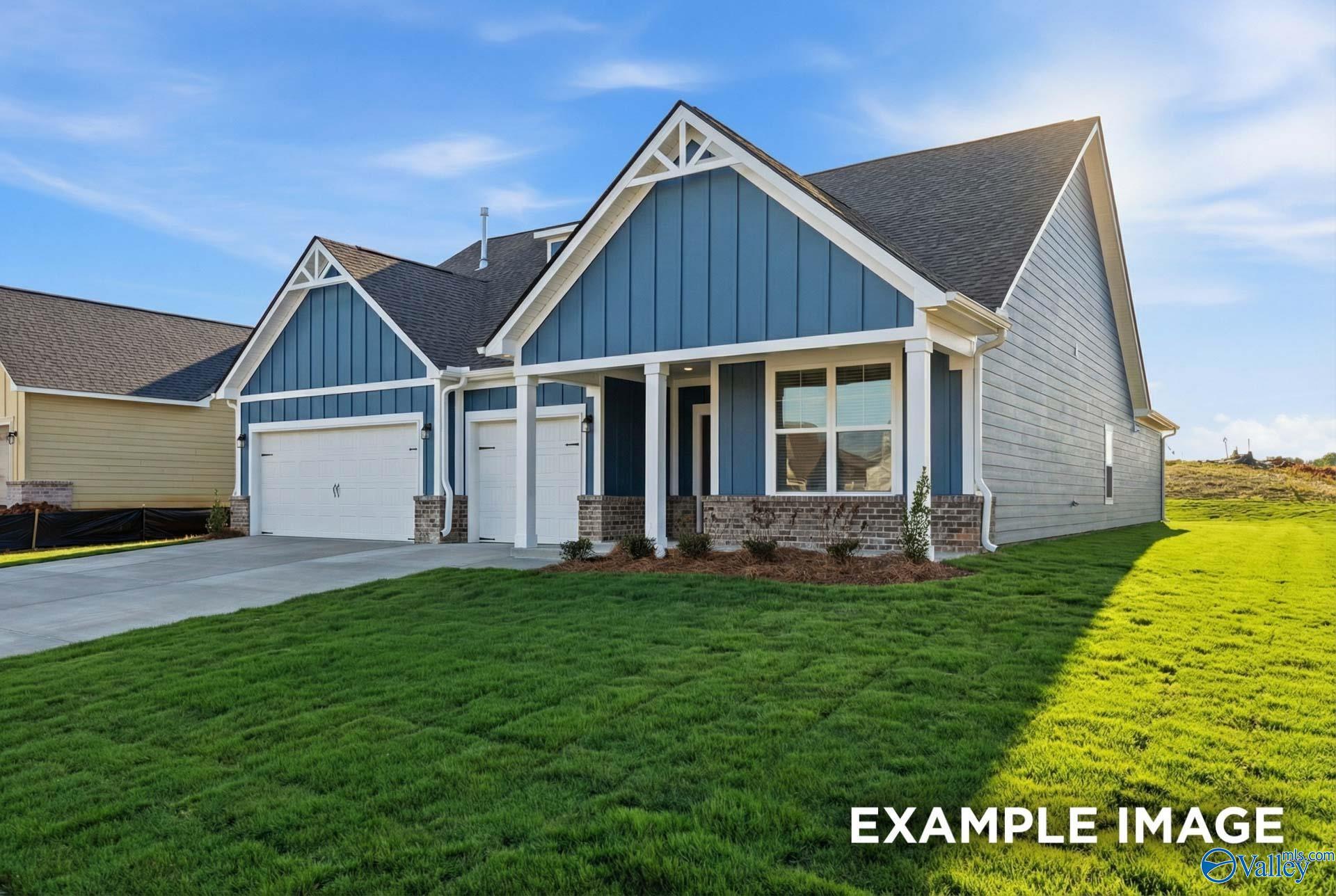 Modern two-story blue-sided home with gabled roof, two-car garage, and landscaped yard in Anderson Farm, Athens, Alabama