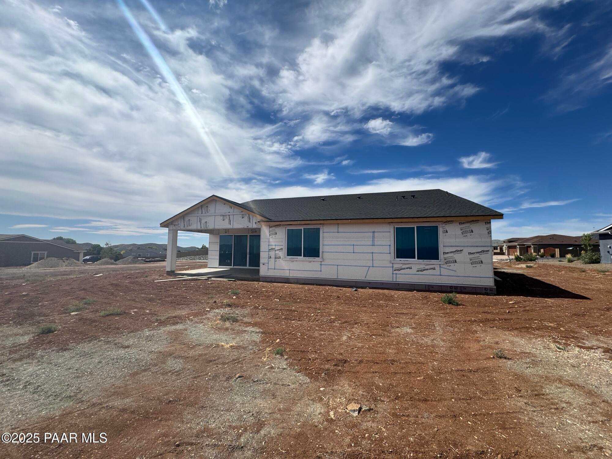 Framed single-story 3-bedroom home with 4-car garage under construction in Morningstar, Prescott Valley, Arizona by Evermore Homes The Sunrise A