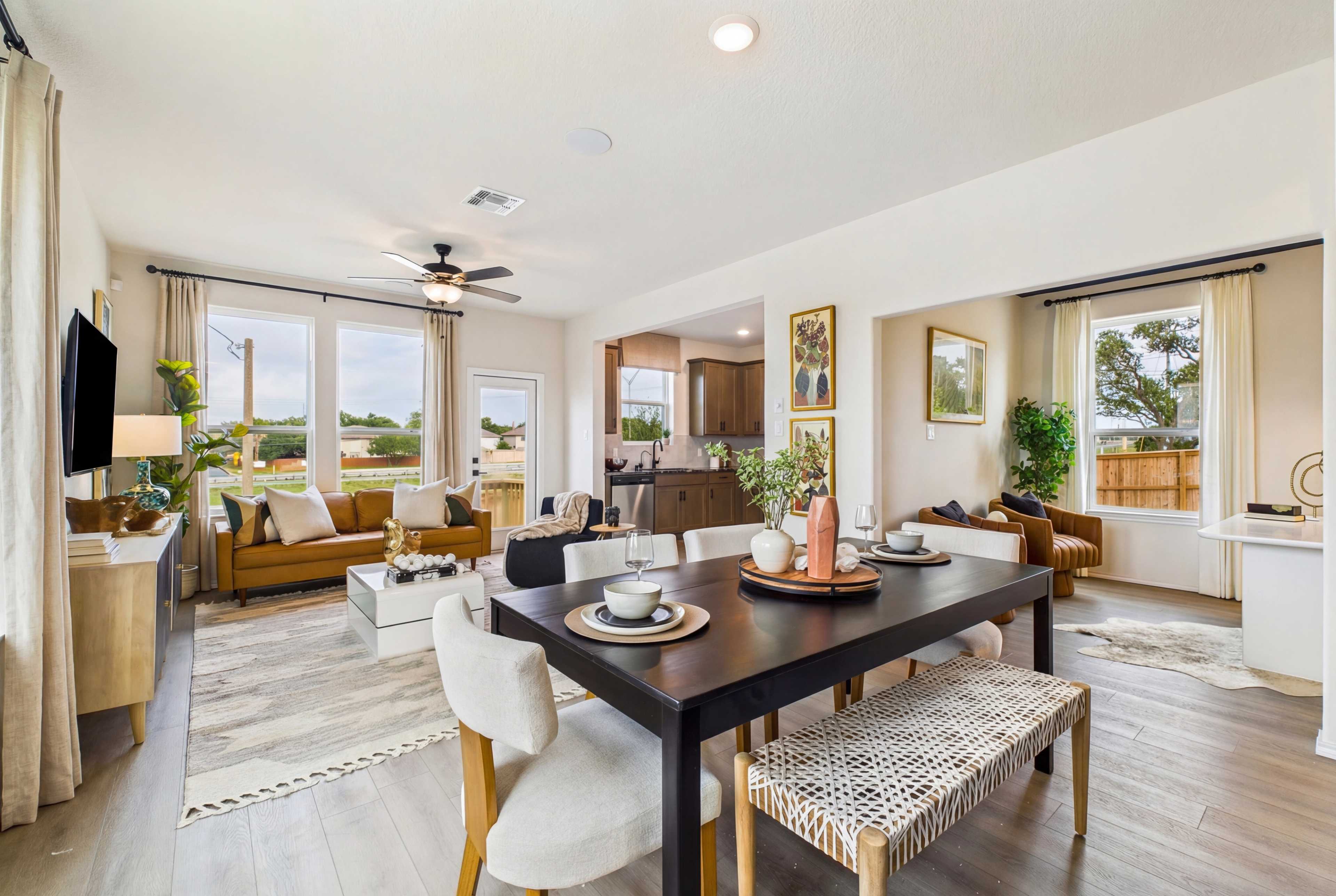 Spacious modern kitchen at Meadows at Oak Creek in San Antonio TX featuring white cabinets, black granite island, stainless steel appliances, and hardwood floors