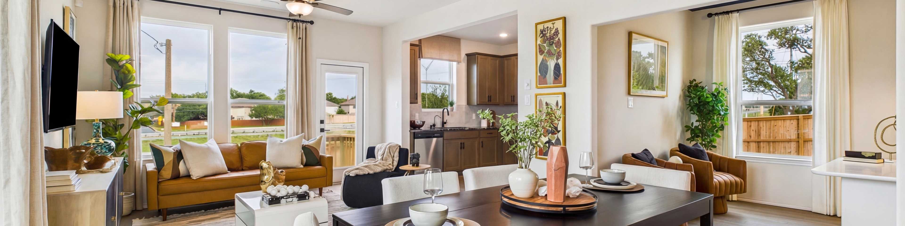 Spacious modern kitchen at Meadows at Oak Creek in San Antonio TX featuring white cabinets, black granite island, stainless steel appliances, and hardwood floors