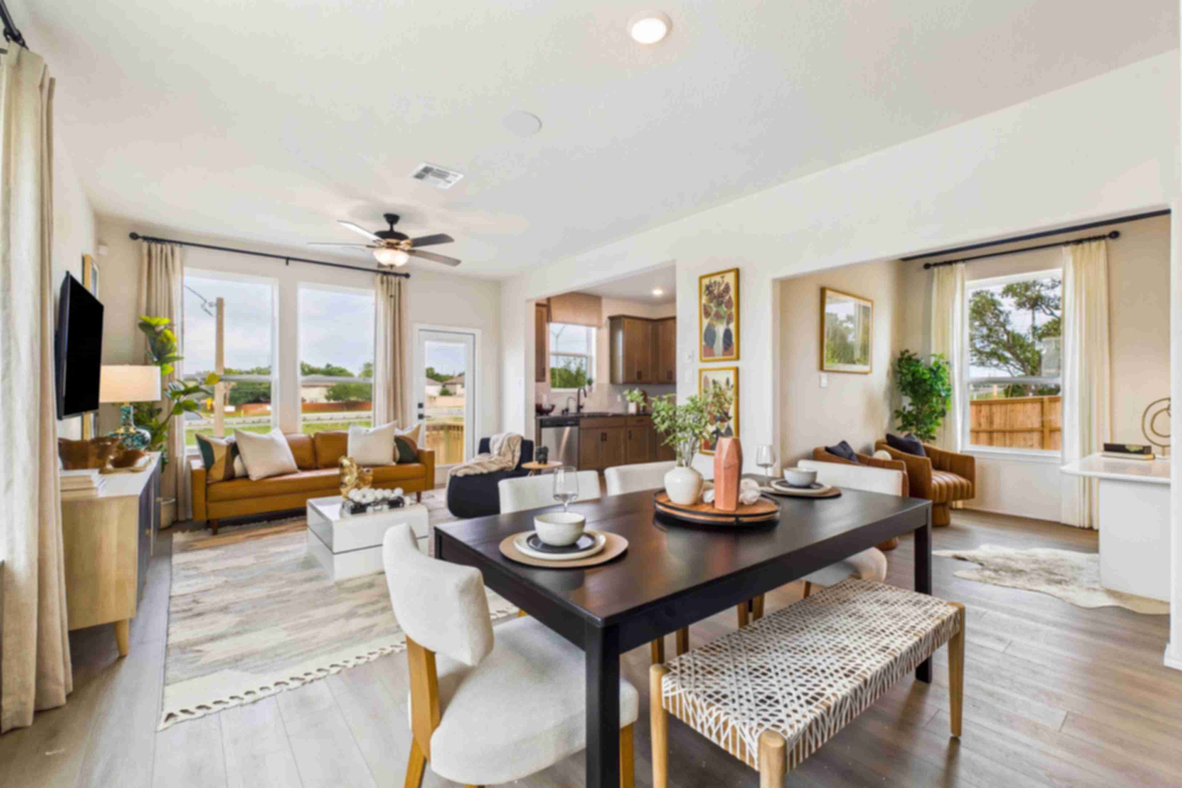 Spacious modern kitchen at Meadows at Oak Creek in San Antonio TX featuring white cabinets, black granite island, stainless steel appliances, and hardwood floors