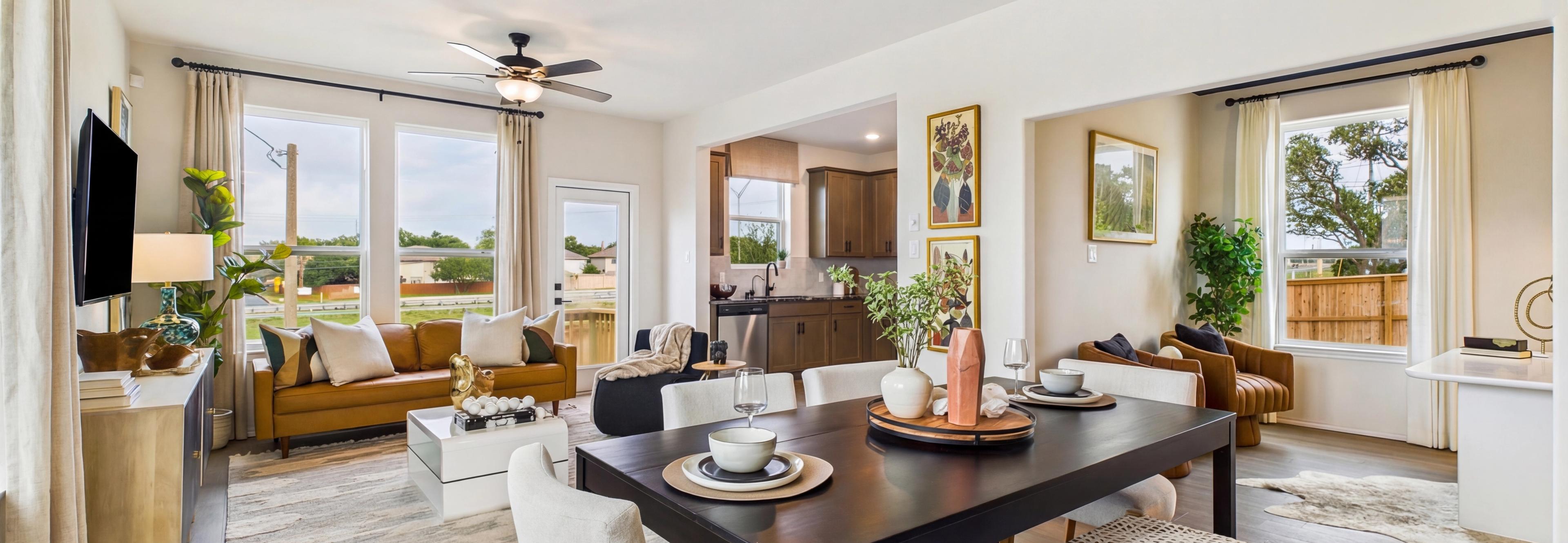 Spacious modern kitchen at Meadows at Oak Creek in San Antonio TX featuring white cabinets, black granite island, stainless steel appliances, and hardwood floors