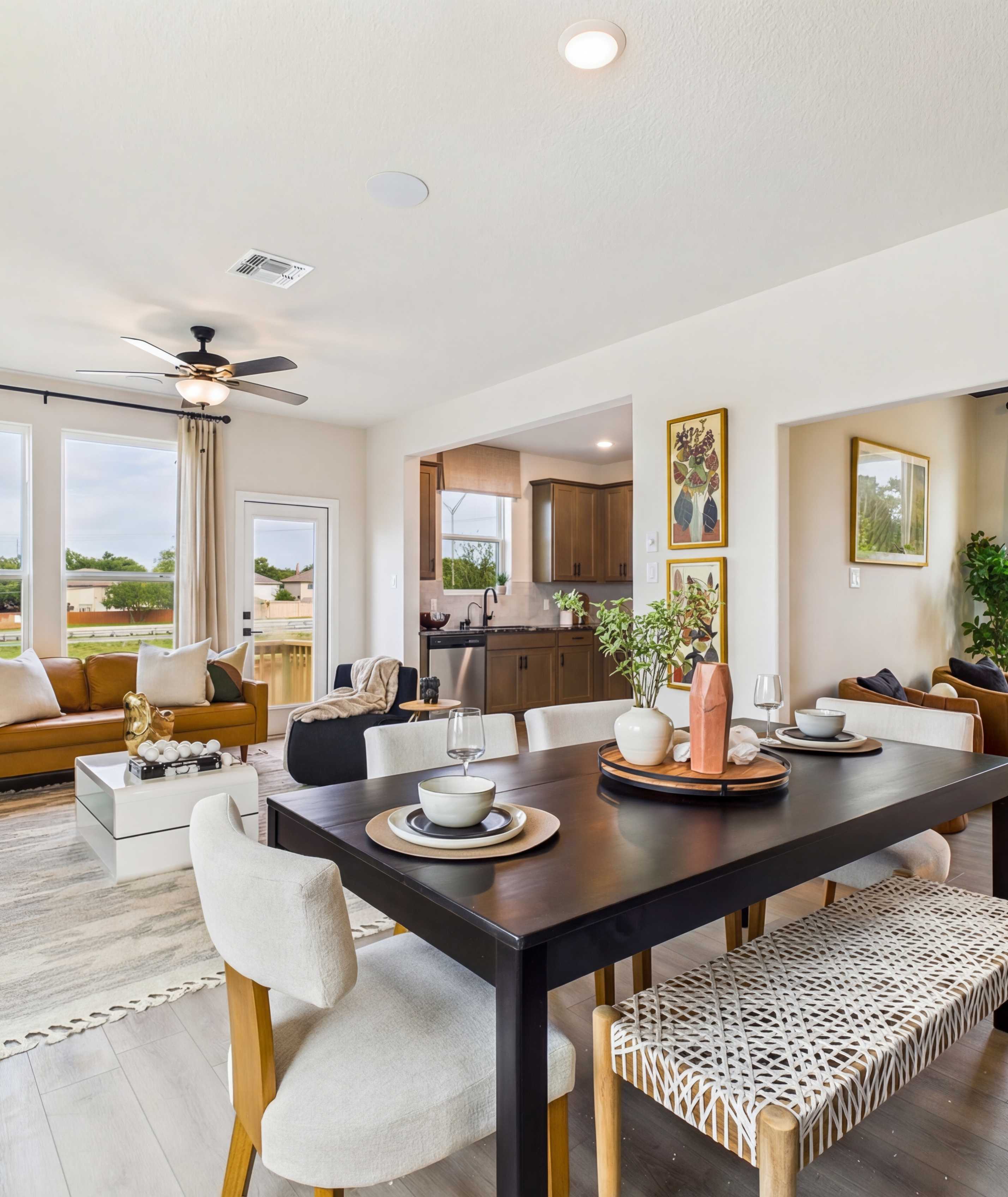 Spacious modern kitchen at Meadows at Oak Creek in San Antonio TX featuring white cabinets, black granite island, stainless steel appliances, and hardwood floors
