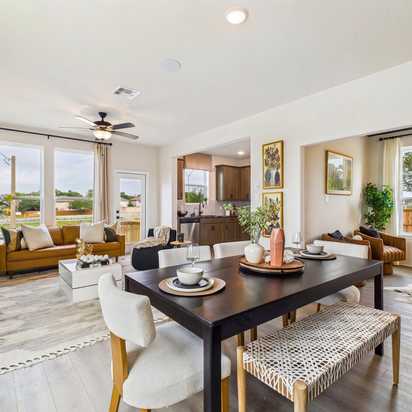 Spacious modern kitchen at Meadows at Oak Creek in San Antonio TX featuring white cabinets, black granite island, stainless steel appliances, and hardwood floors