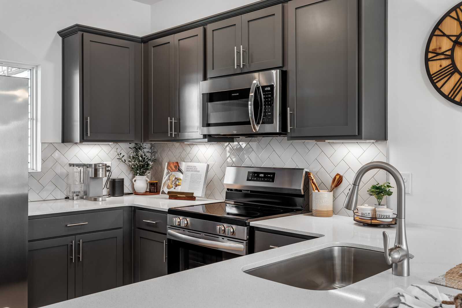 Contemporary kitchen at The Towns at Red River in Gallatin TN featuring gray shaker cabinets, stainless steel appliances, subway tile backsplash
