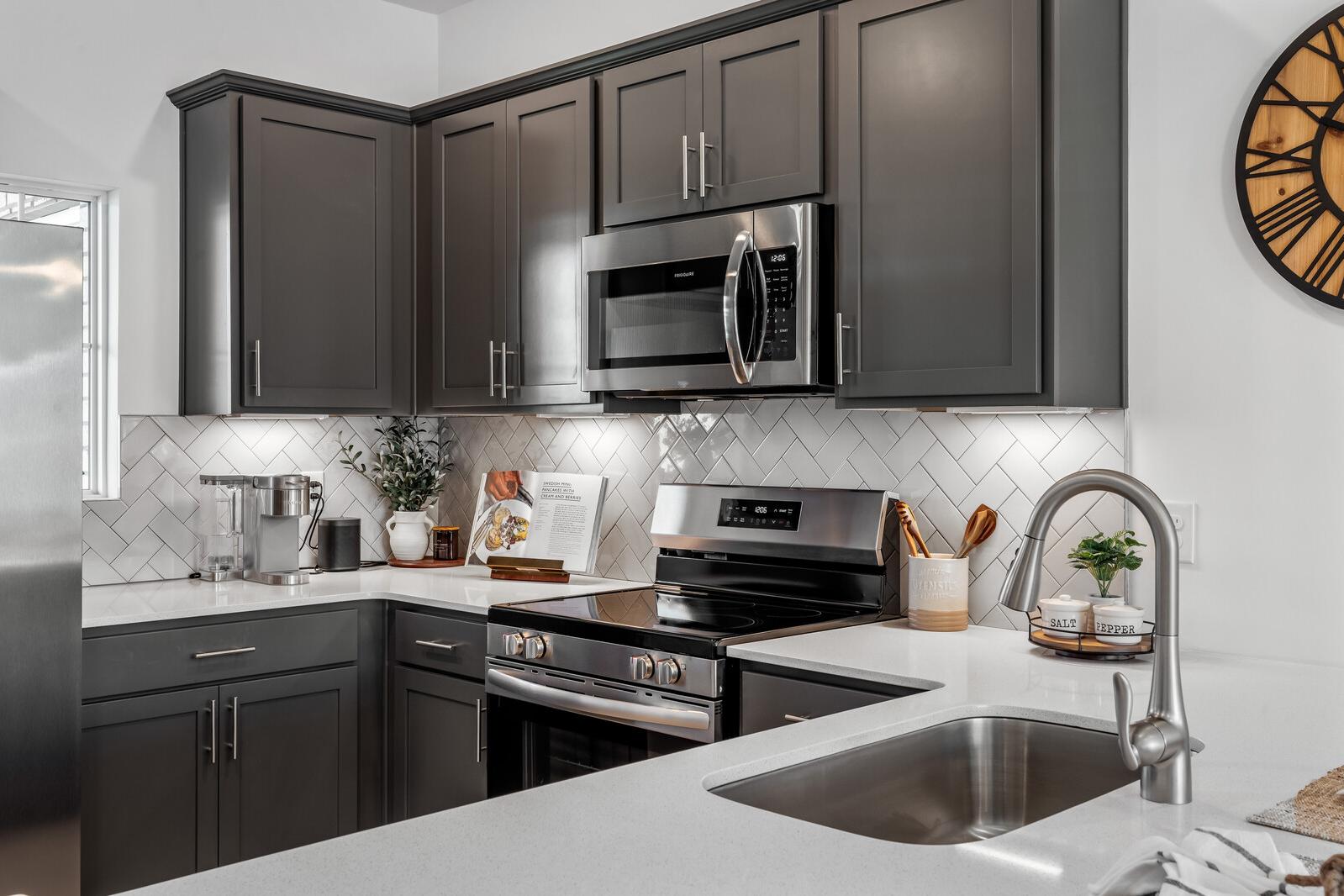 Contemporary kitchen at The Towns at Red River in Gallatin TN featuring gray shaker cabinets, stainless steel appliances, subway tile backsplash