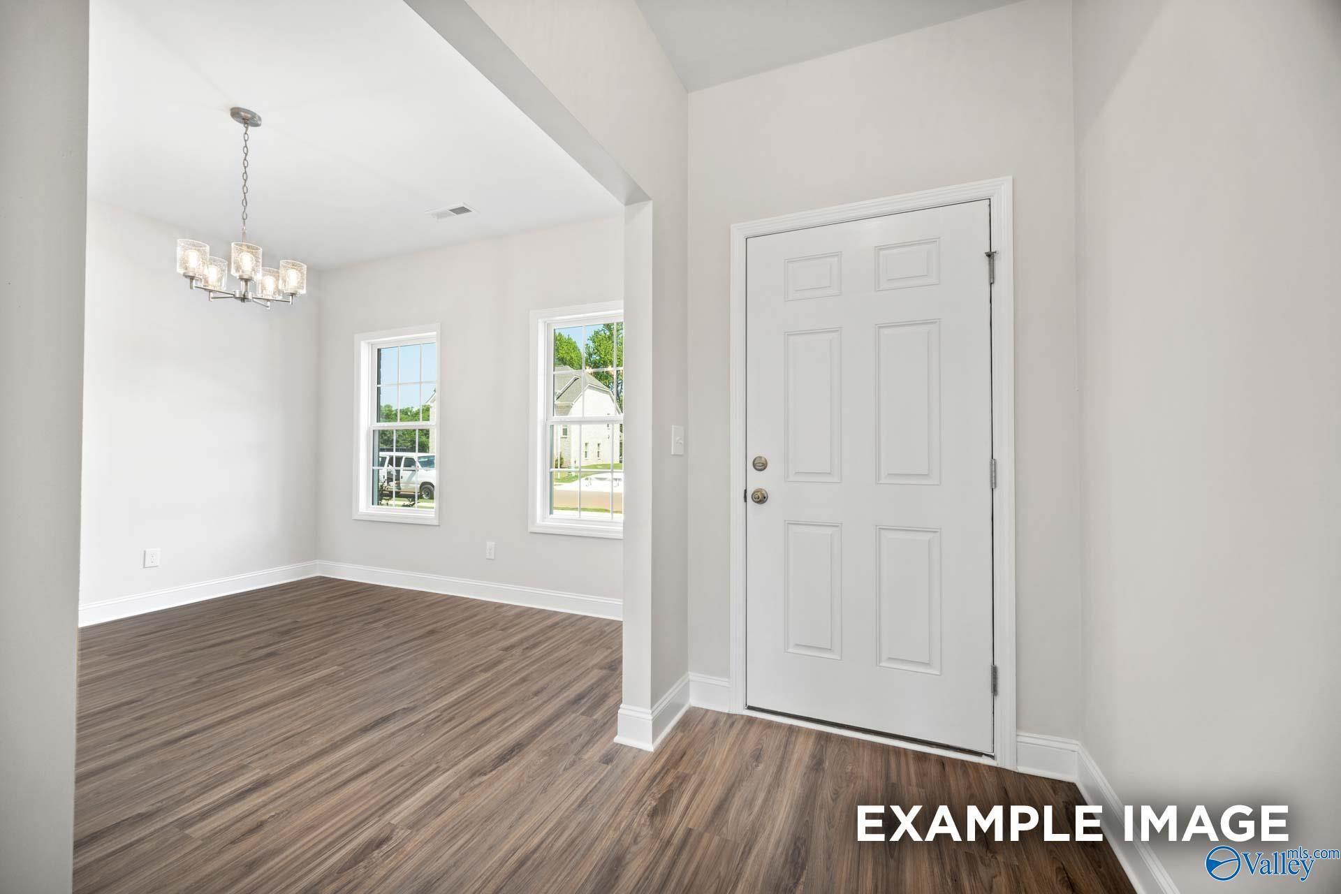 Bright dining area with elegant chandelier and wood-look flooring at The Shelby B in Jaguar Hills, Huntsville, Alabama.