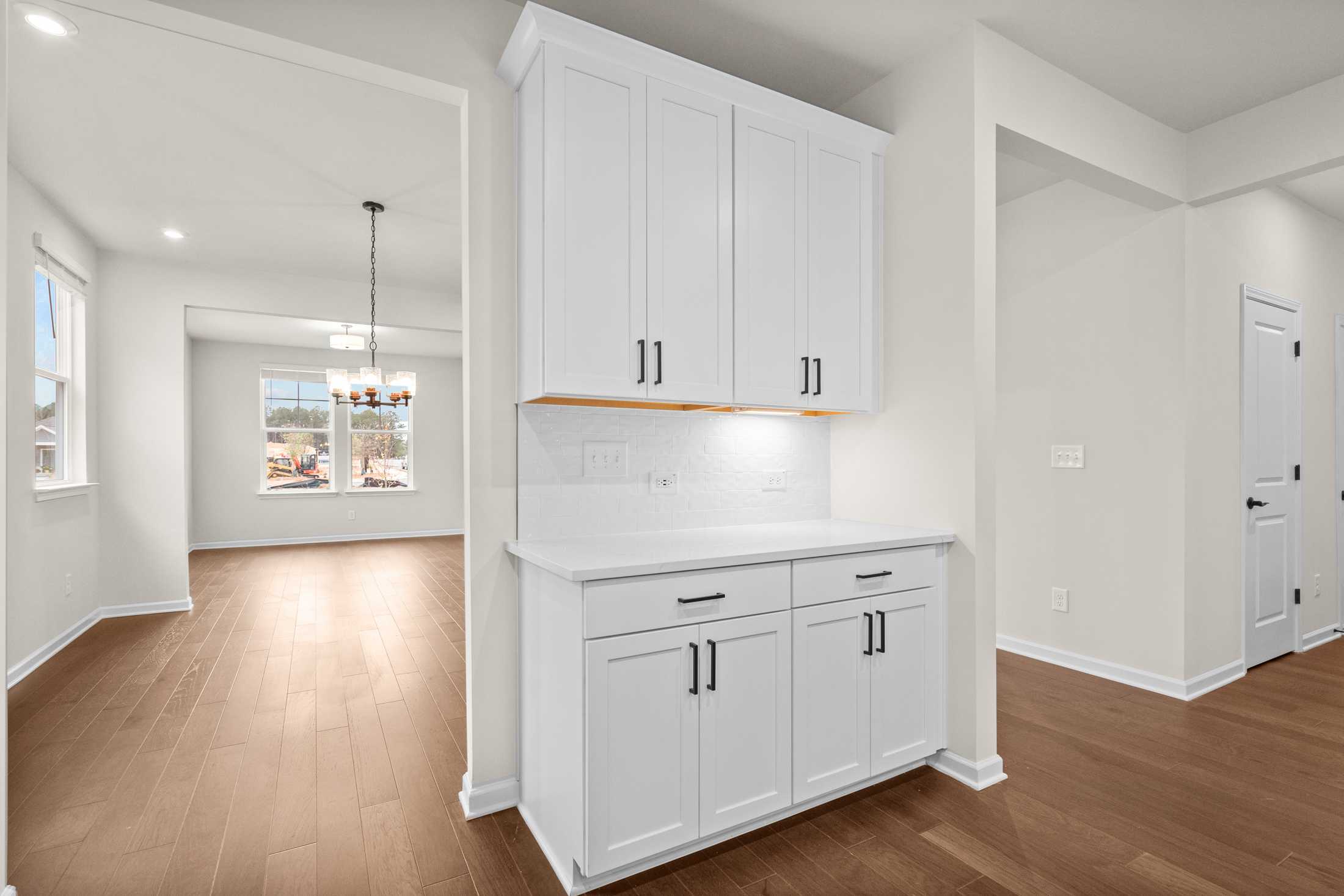Spacious butler's pantry in The Glenwood B with white shaker cabinets, farmhouse sink, and hardwood floors