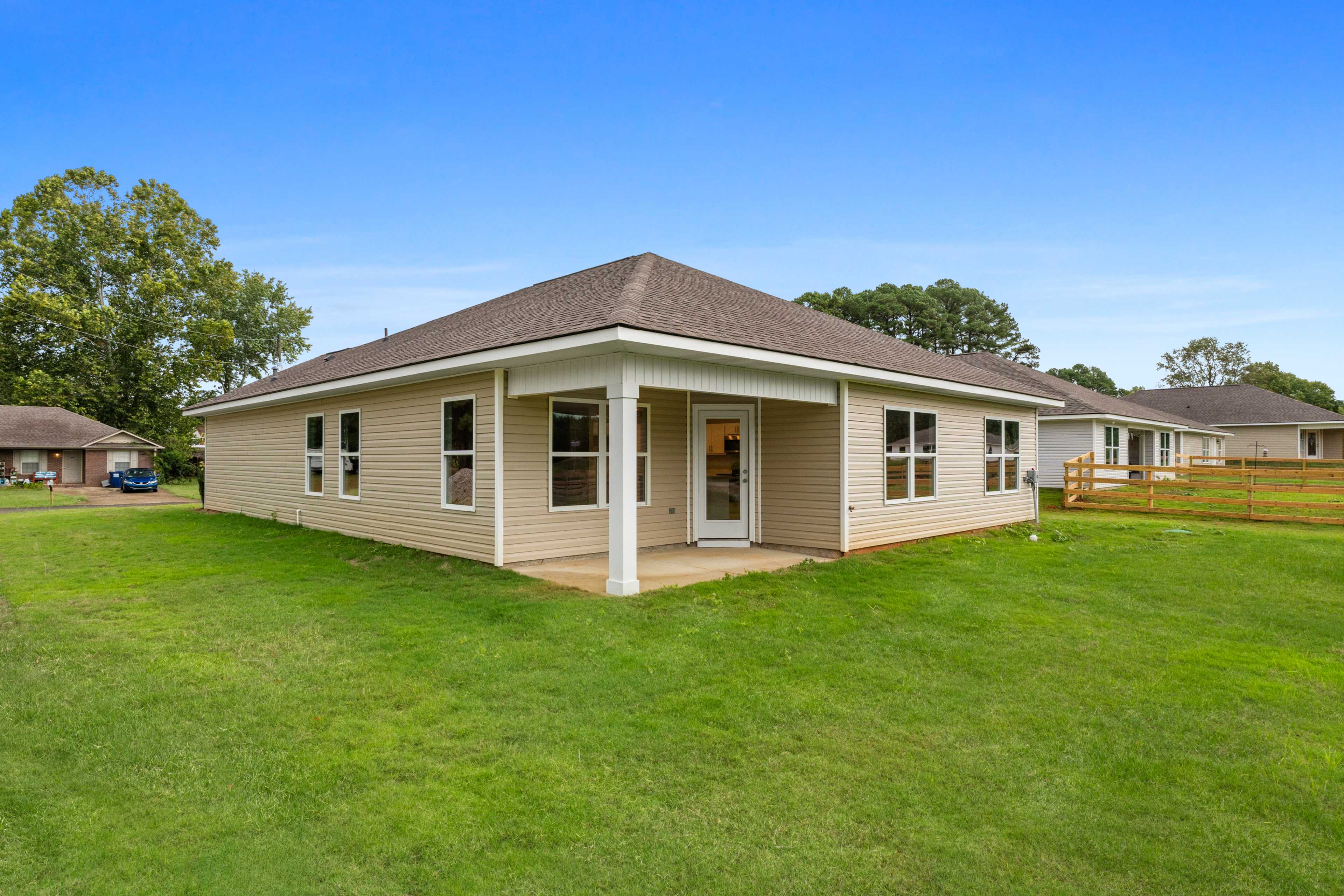 Beige ranch-style home exterior at Collins Lane in Meridianville, Alabama with covered front porch and green lawn