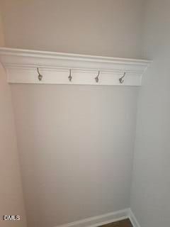 White wall-mounted coat rack with crown molding shelf in The Daphne D floor plan at Woodland Crossing in Zebulon, NC.