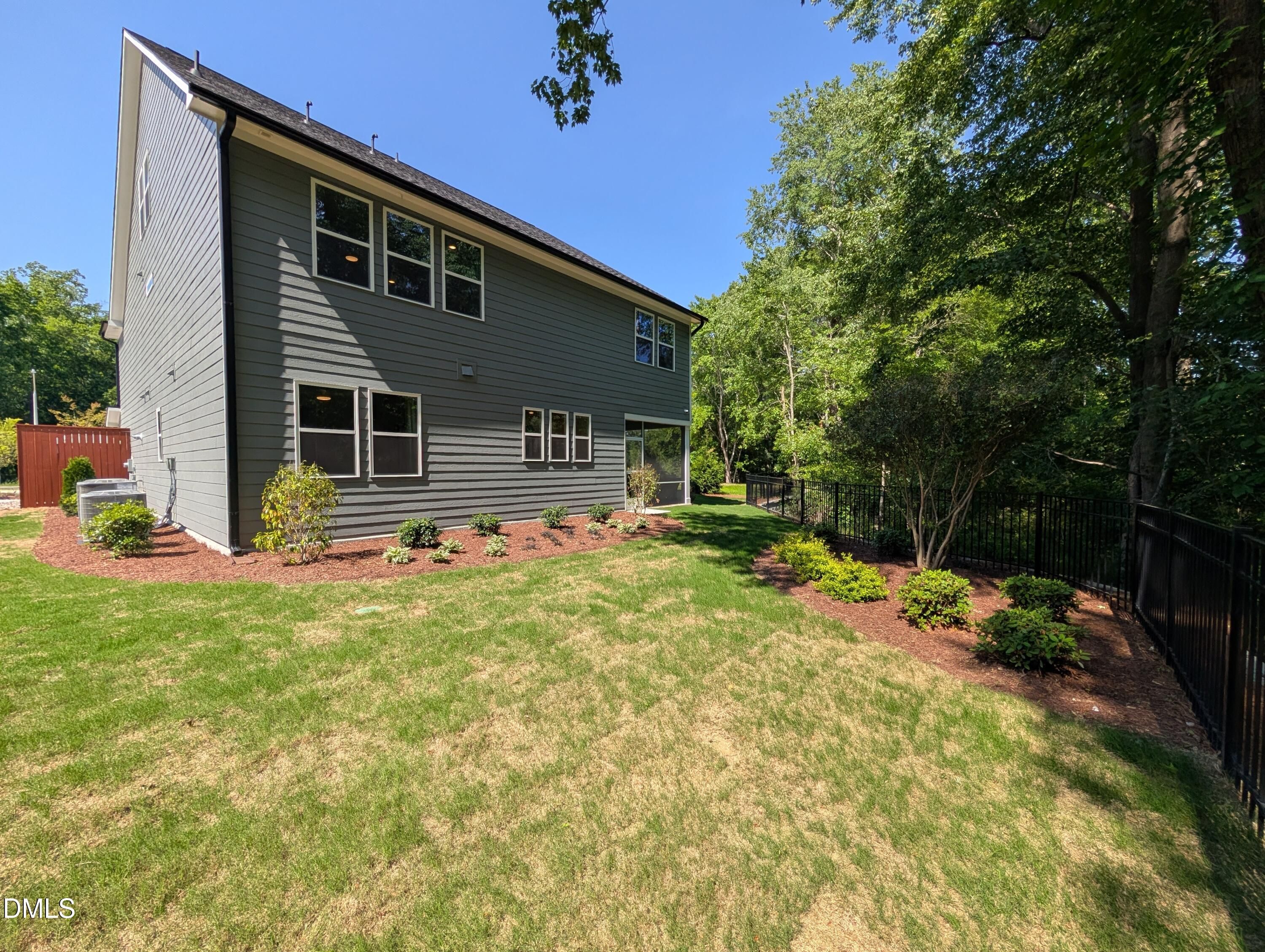 Exterior side view of 2-story Aspen B floor plan by Davidson Homes with fenced backyard in Wendell Ridge, North Carolina.